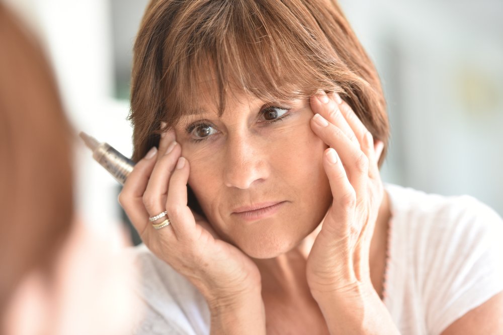 Mujer mayor mirándose en un espejo. | Foto: Shutterstock