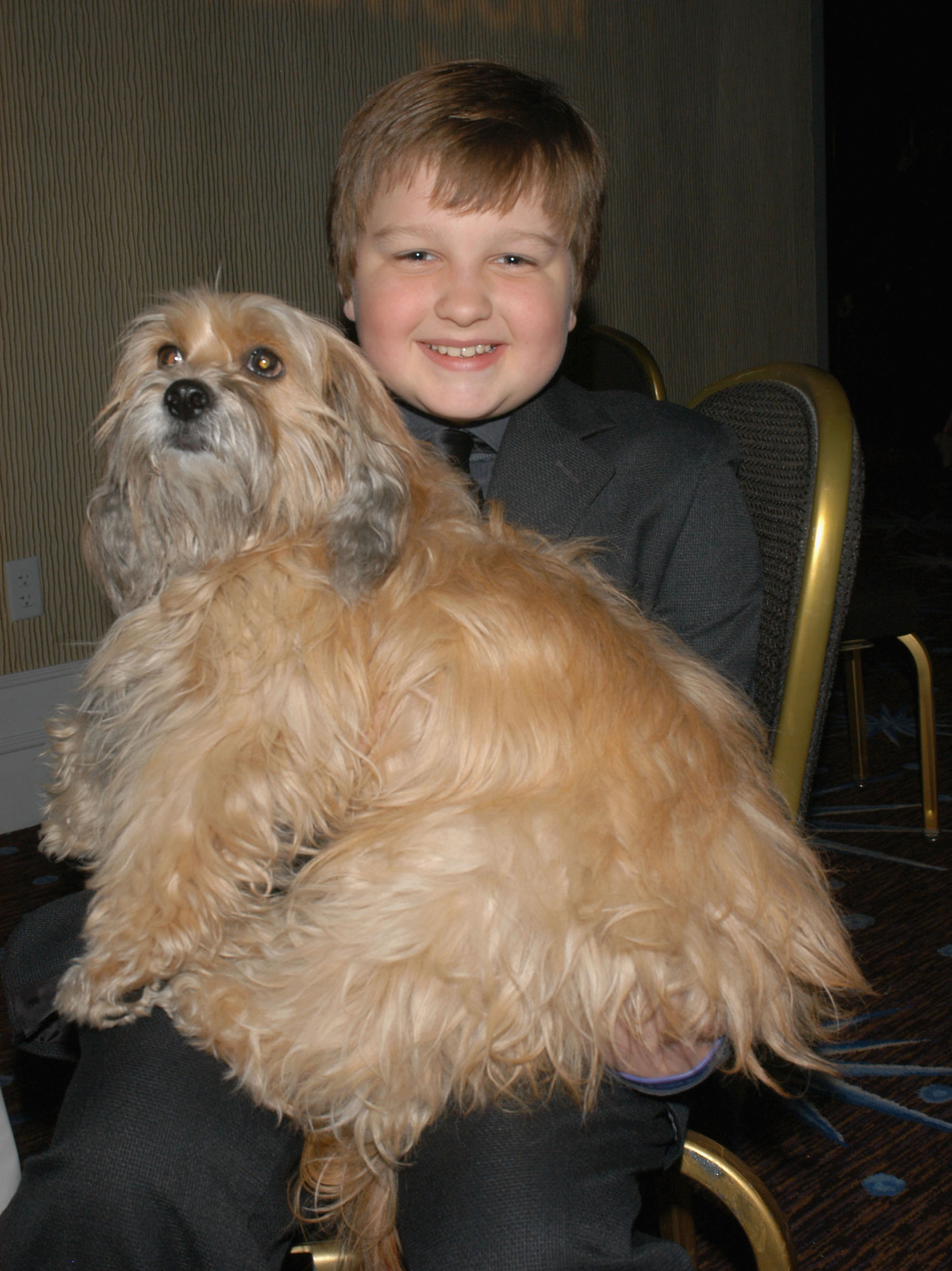 Angus T. Jones sitting with a dog in Los Angeles in 2005 | Source: Getty Images