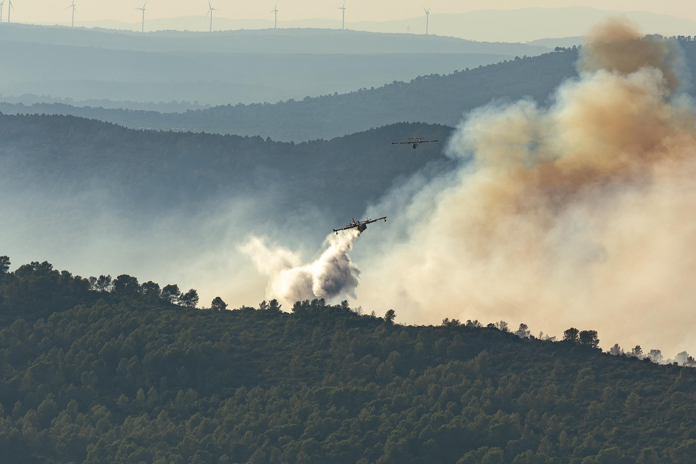 Firefighting aircraft drop water over a wildfire near Brignoles, where flames burned about 130 hectares before crews brought the blaze under control. | Source: Getty Images