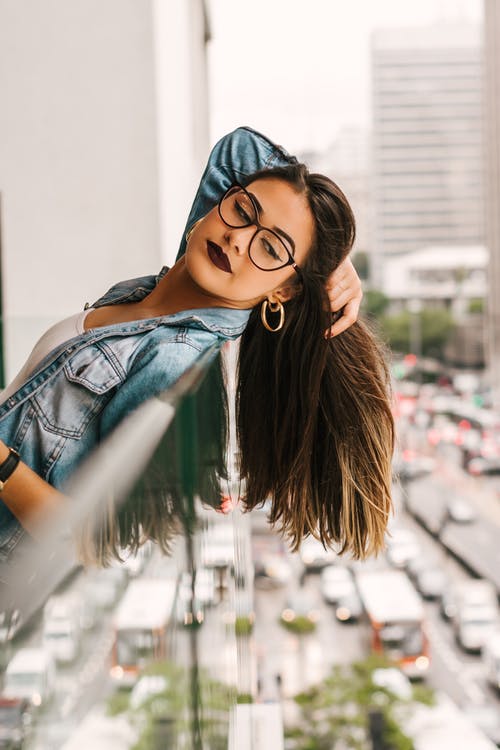 Mujer recostada de una barandilla utilizando lentes de pasta y maquillaje llamativo. | Foto: Pexels Mujer recostada de una barandilla utilizando lentes de pasta y maquillaje llamativo. | Foto: Pexels