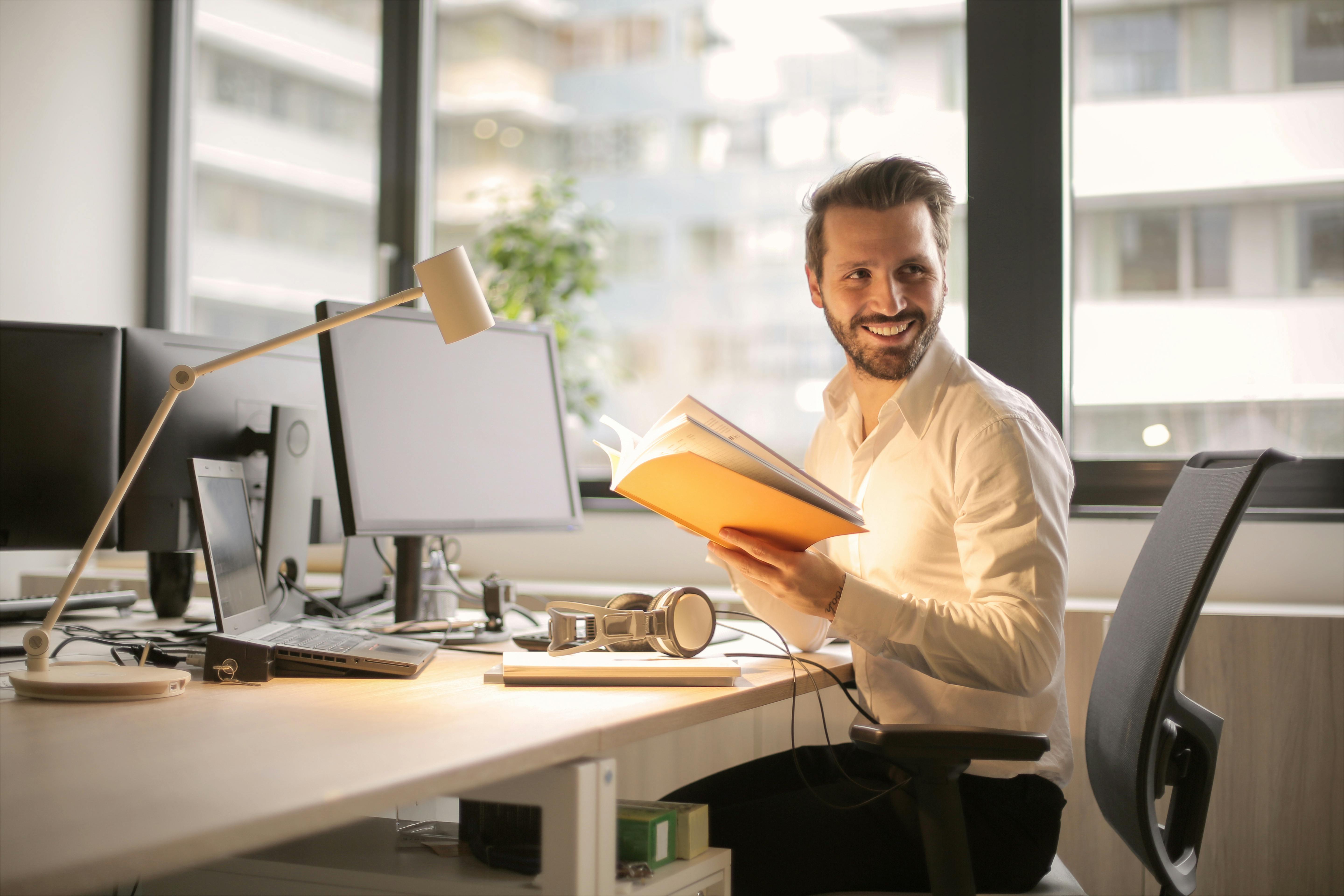 A happy man smiling while working | Source: Pexels
