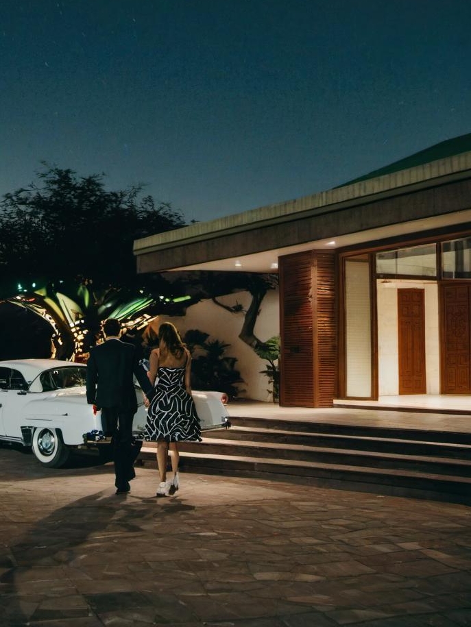 A couple approaching a house at night | Source: Midjourney