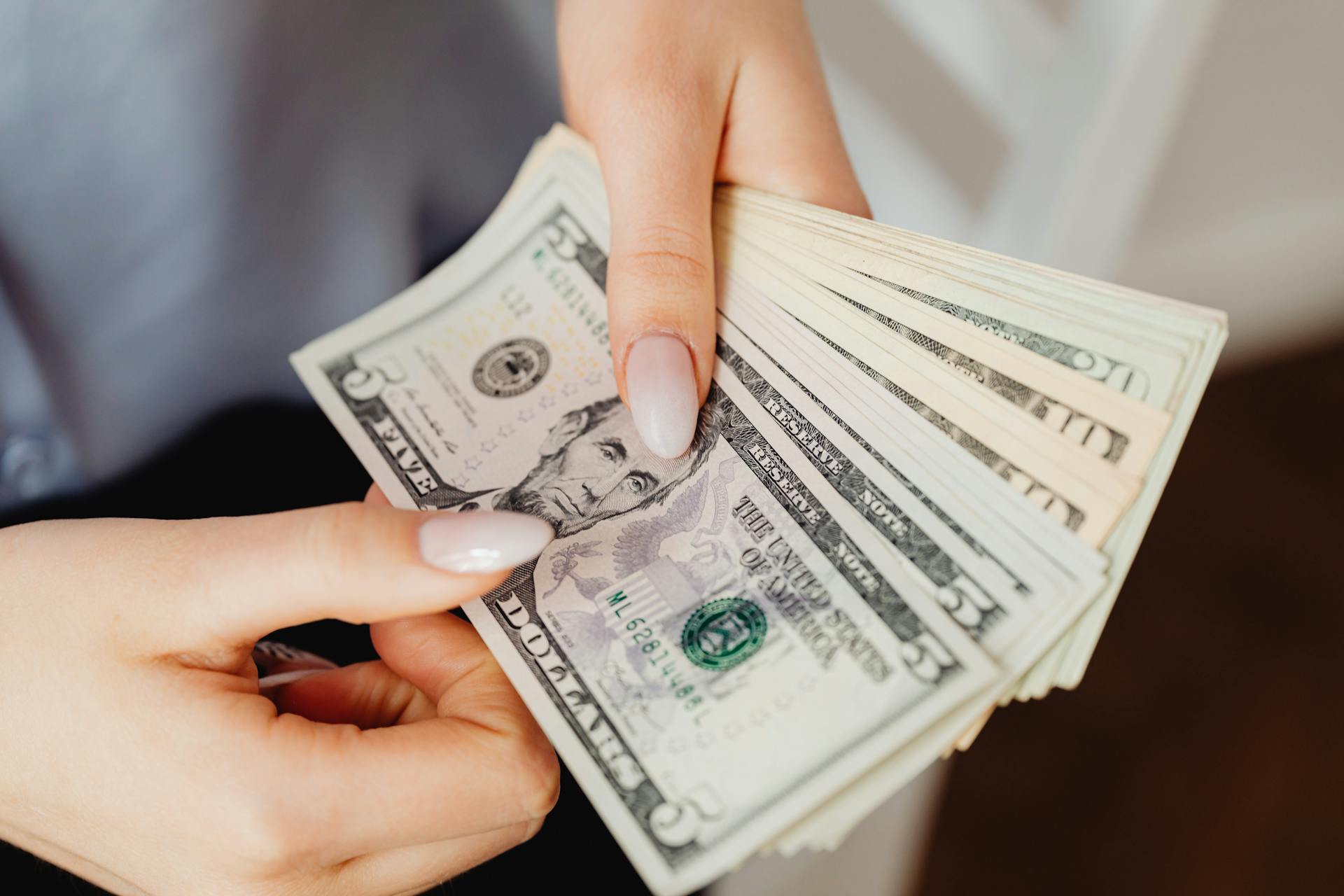 A woman holding dollar bills | Source: Pexels