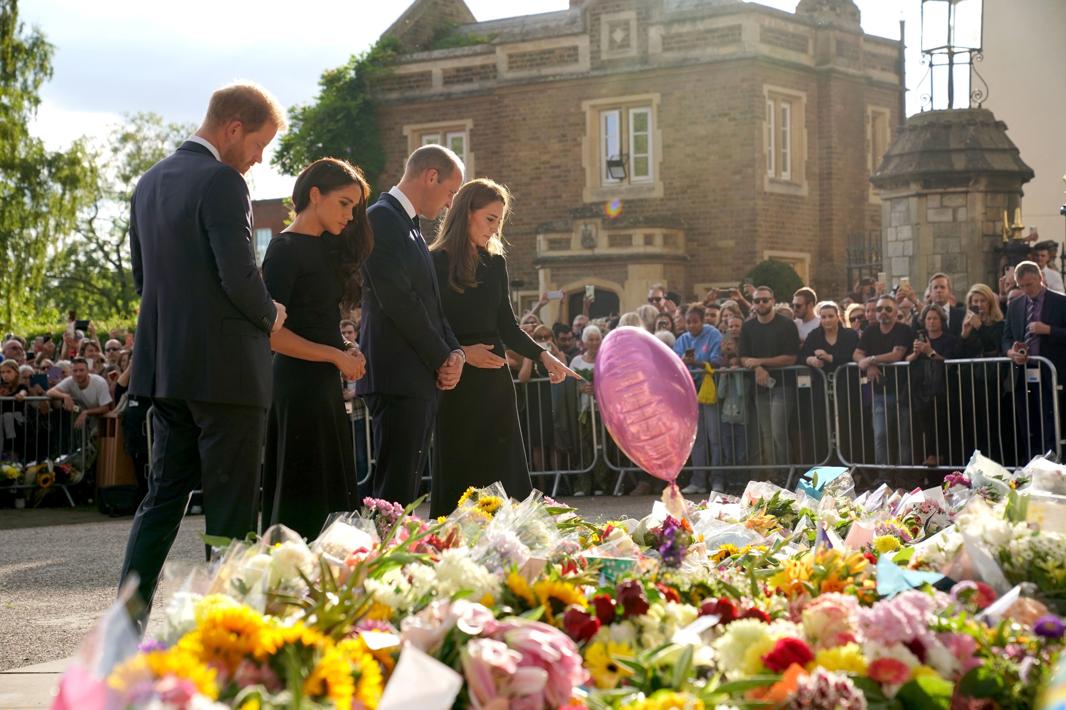 Prince Harry, Duke of Sussex, Meghan, Duchess of Sussex, Catherine, Princess of Wales and Prince William, Prince of Wales view floral tributes left at Windsor Castle on September 10, 2022 in Windsor, England | Source: Getty Images