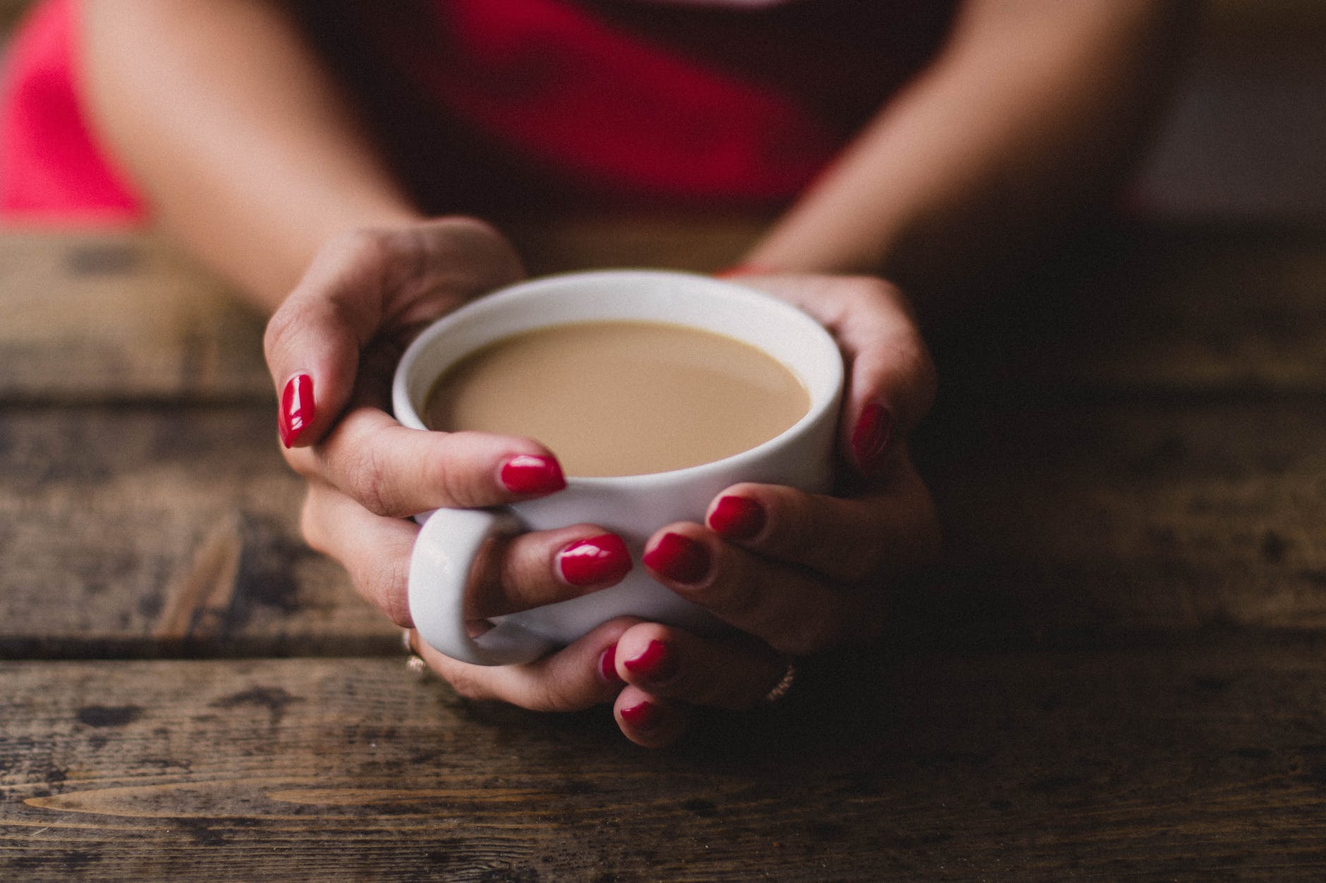 Una mujer sosteniendo una tasa de café con leche. | Foto: Pexels