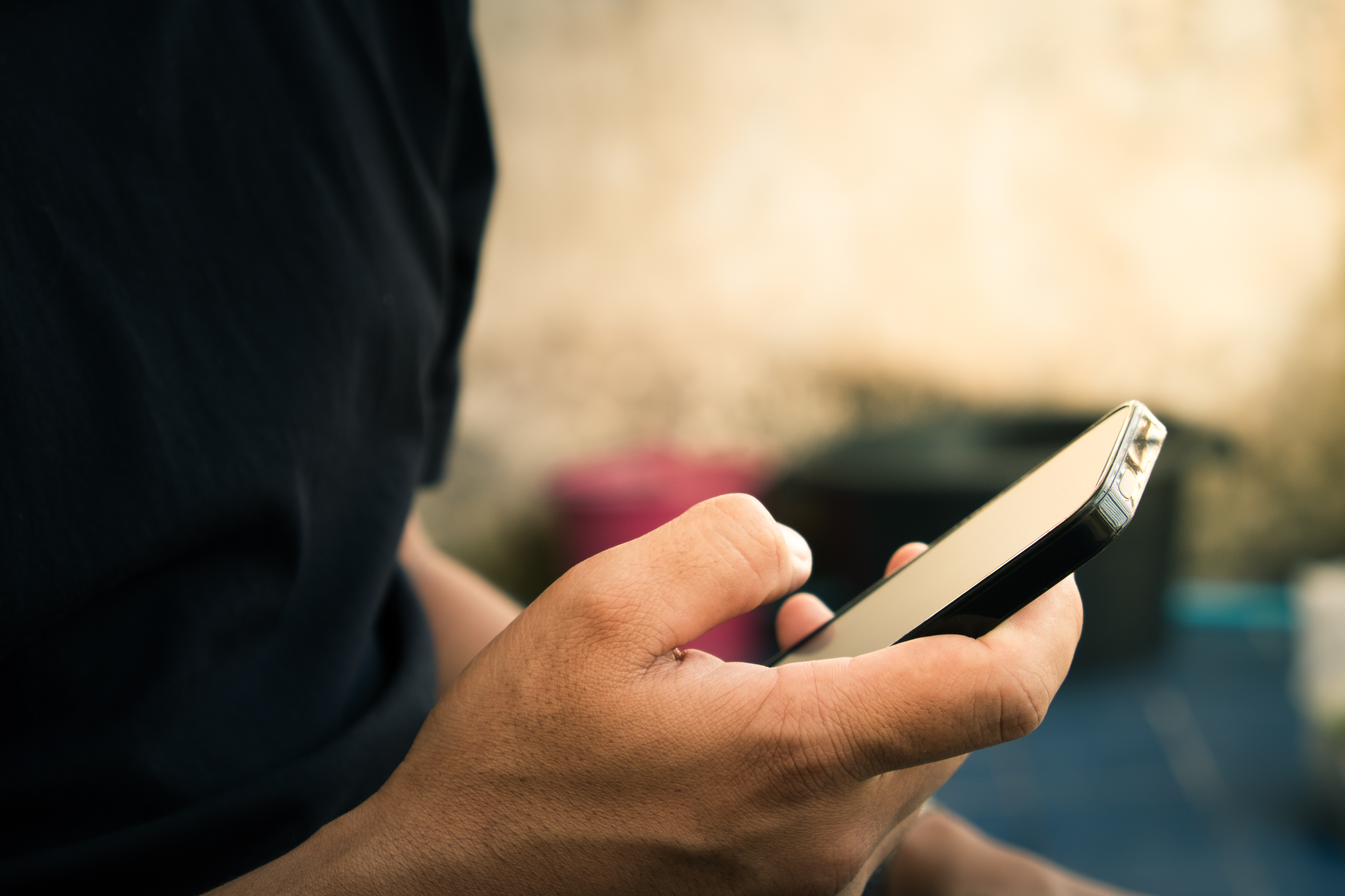 A man's hand using a phone to text | Source: Shutterstock