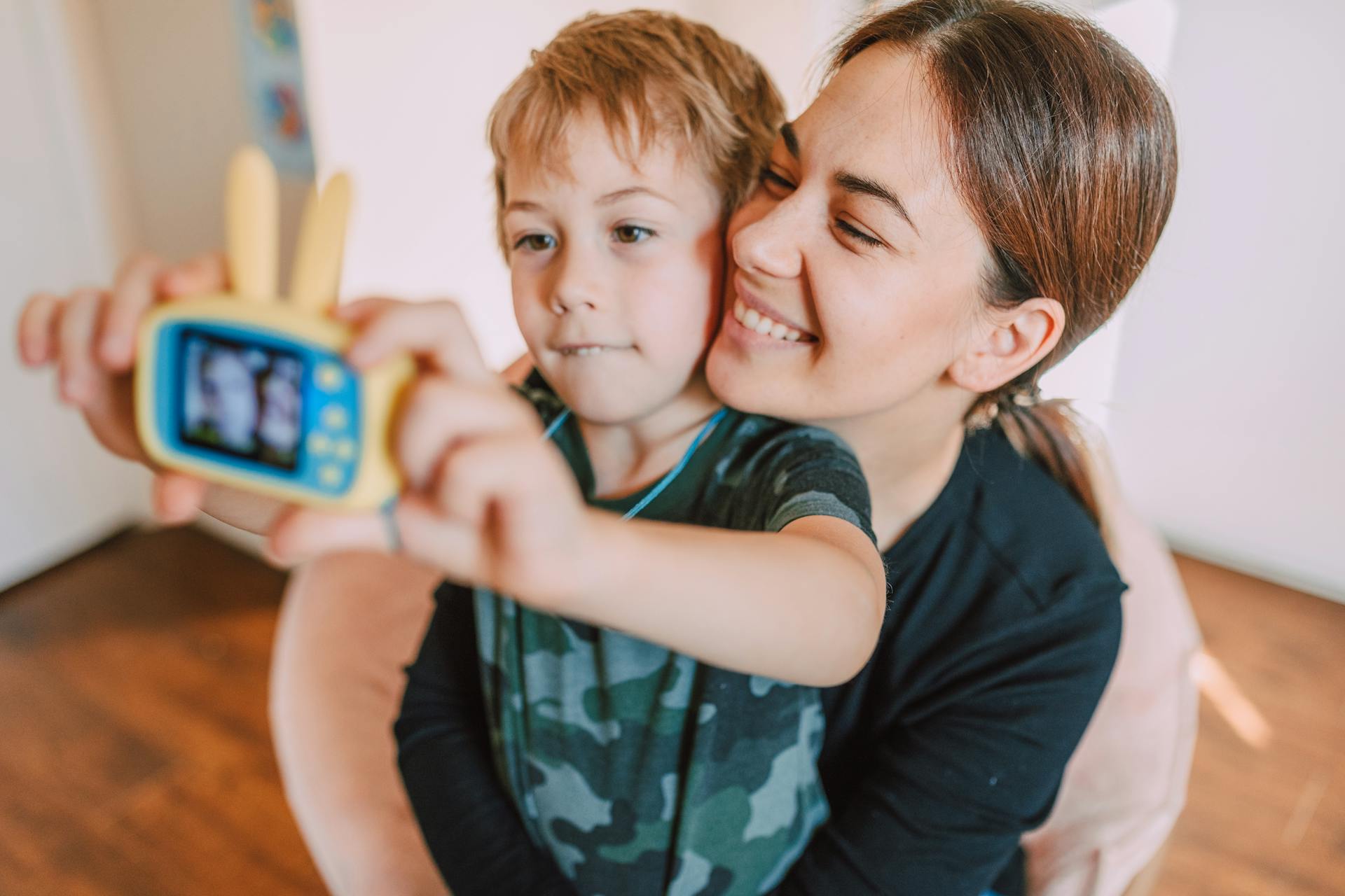 Young boy taking a picture with his mother | Source: Pexels