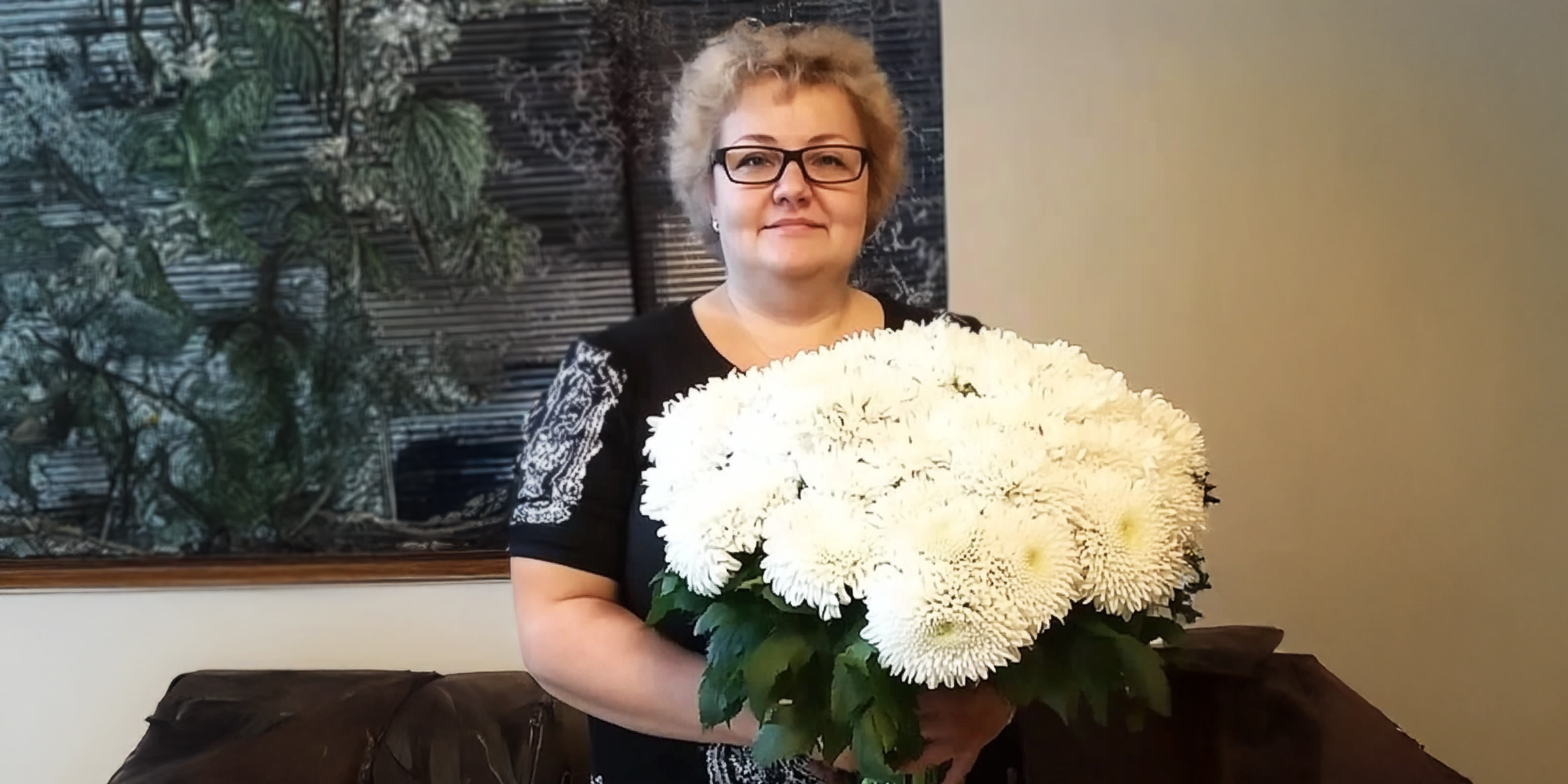 A smiling senior woman holding a bouquet of flowers | Source: AmoMama