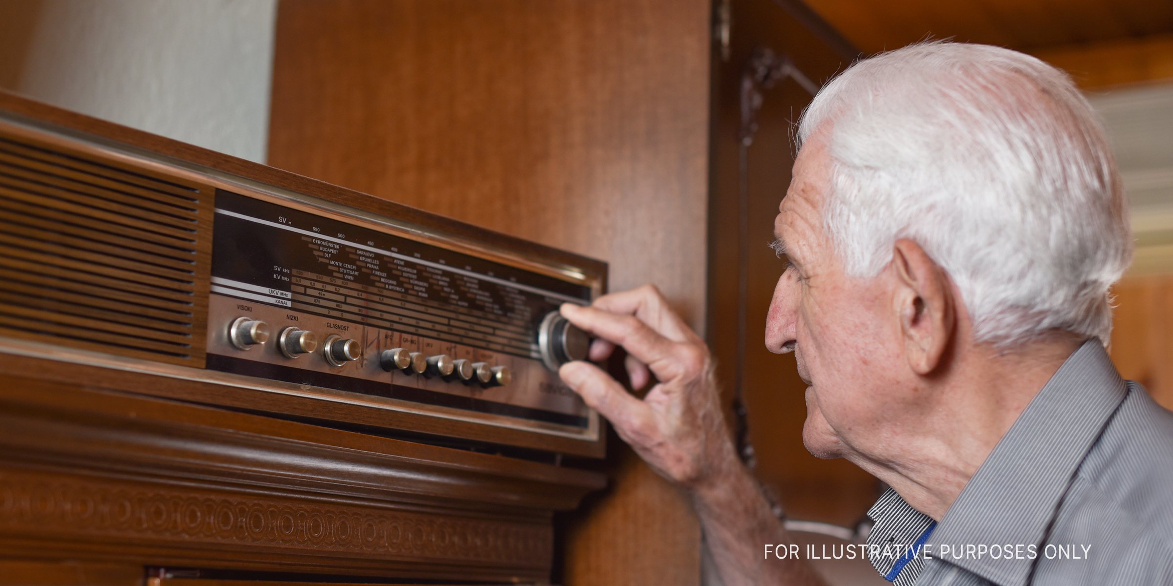 Elderly man tunes frequency on an old-fashioned radio | Source: Getty Images