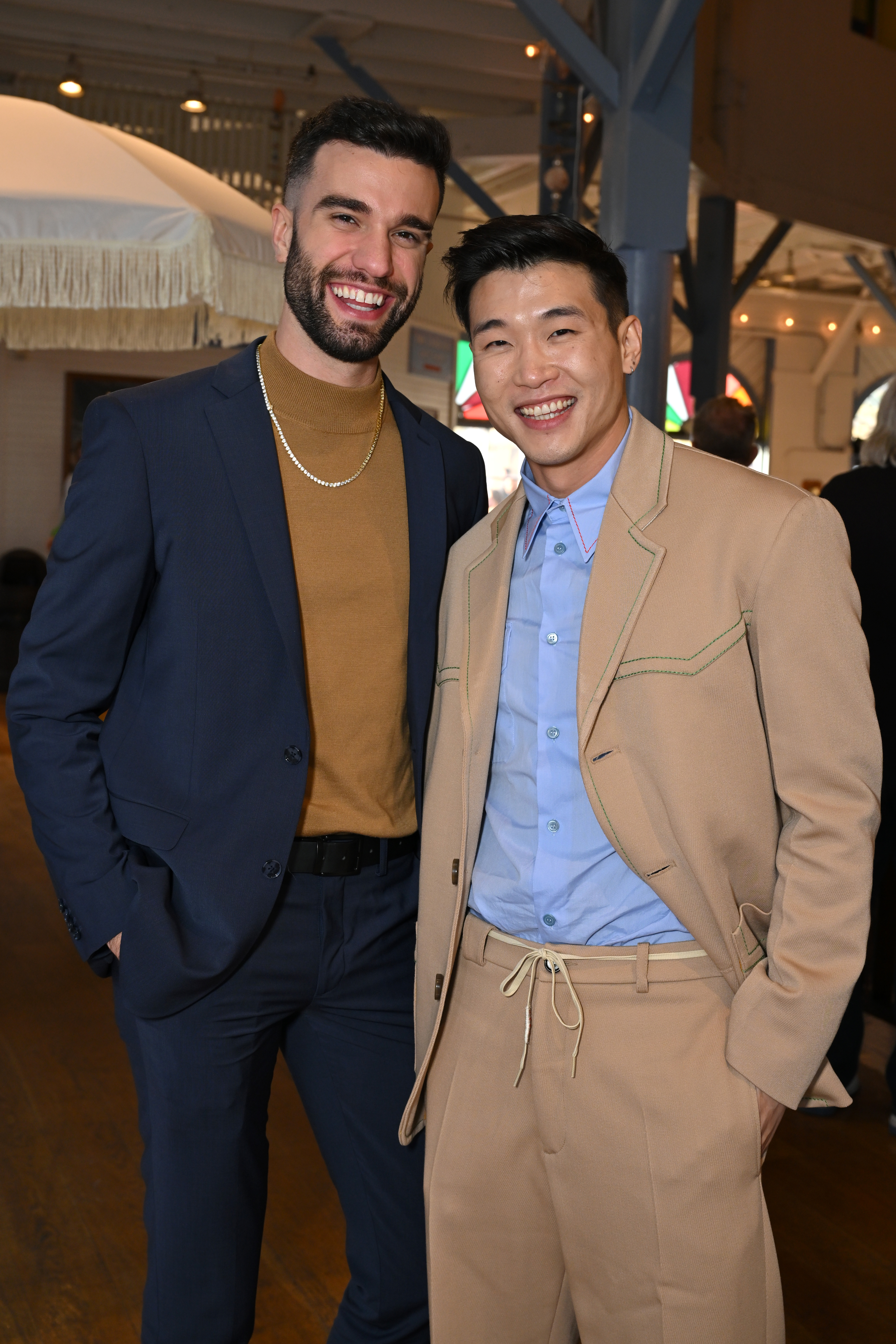 Joel Kim Booster and John-Michael Sudsina are pictured at the 2023 Film Independent Spirit Awards After Party at the Santa Monica Pier on March 4, 2023 in Santa Monica, California |  Source: Getty Images