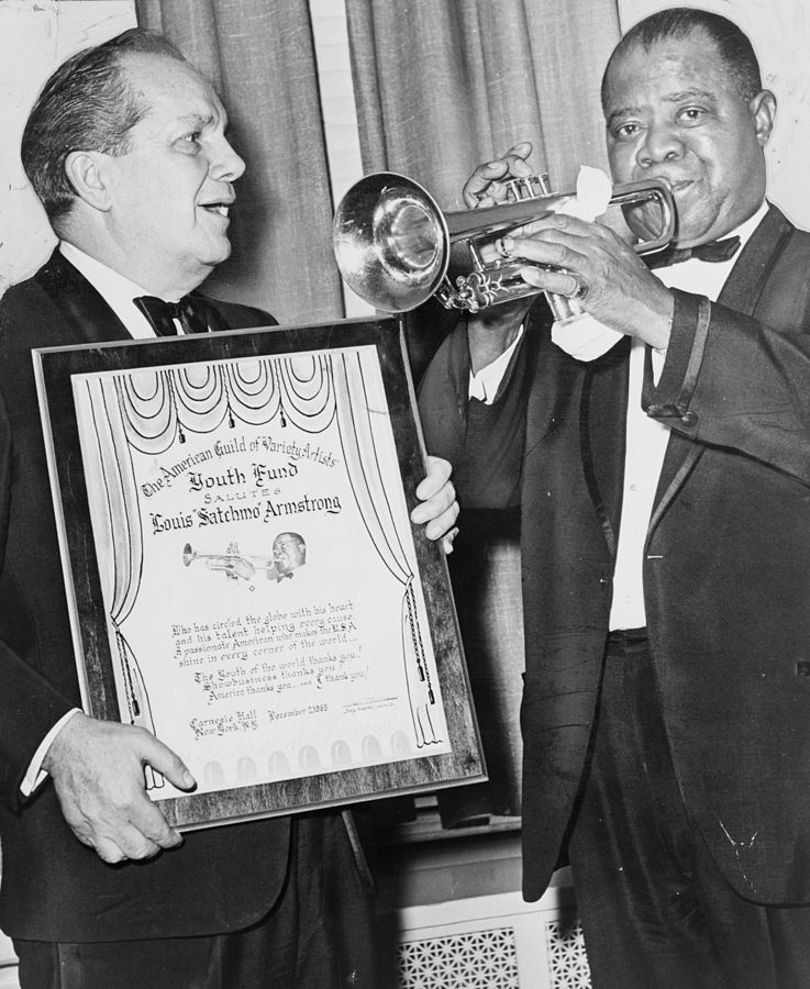 Louis Armstrong plays trumpet with Joey Adams, president of the American Guild of Variety Artists Youth Fund. | Photo: Wikimedia Commons Images
