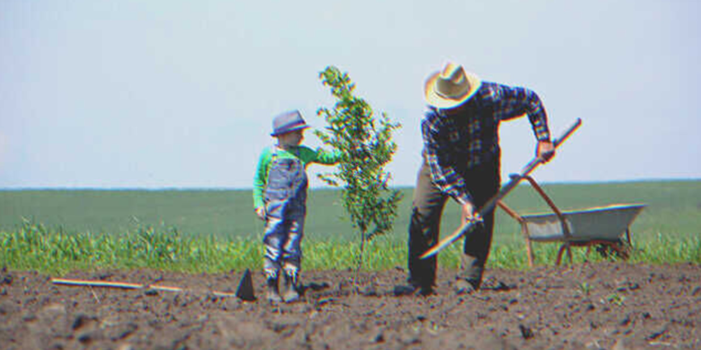 Un niño y un hombre plantando un árbol | Foto: Shutterstock