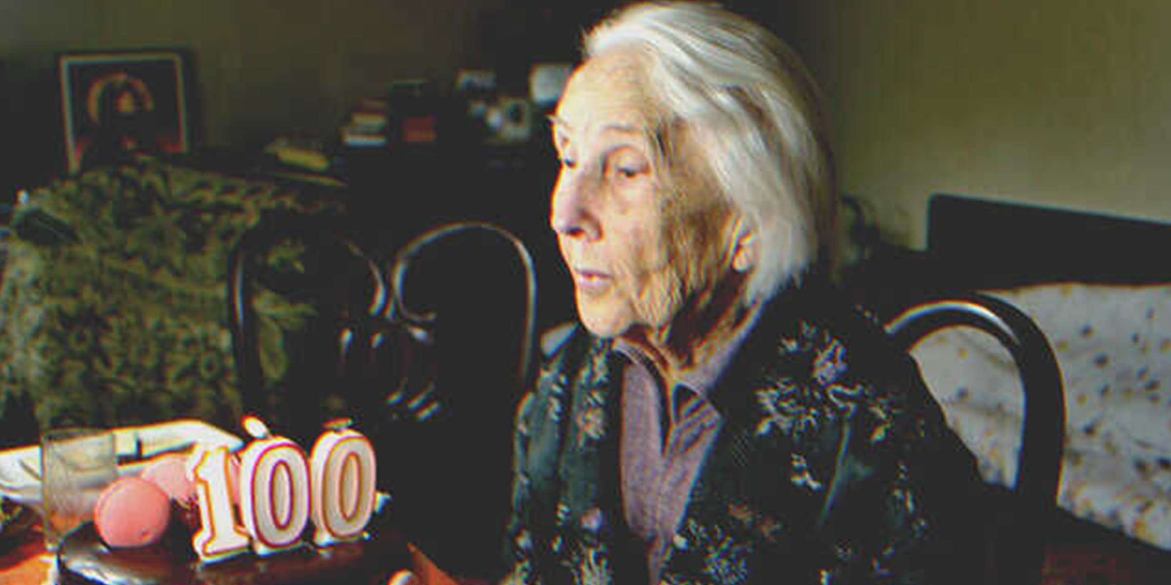 Una mujer con un pastel de cumpleaños número 100 | Foto: Shutterstock