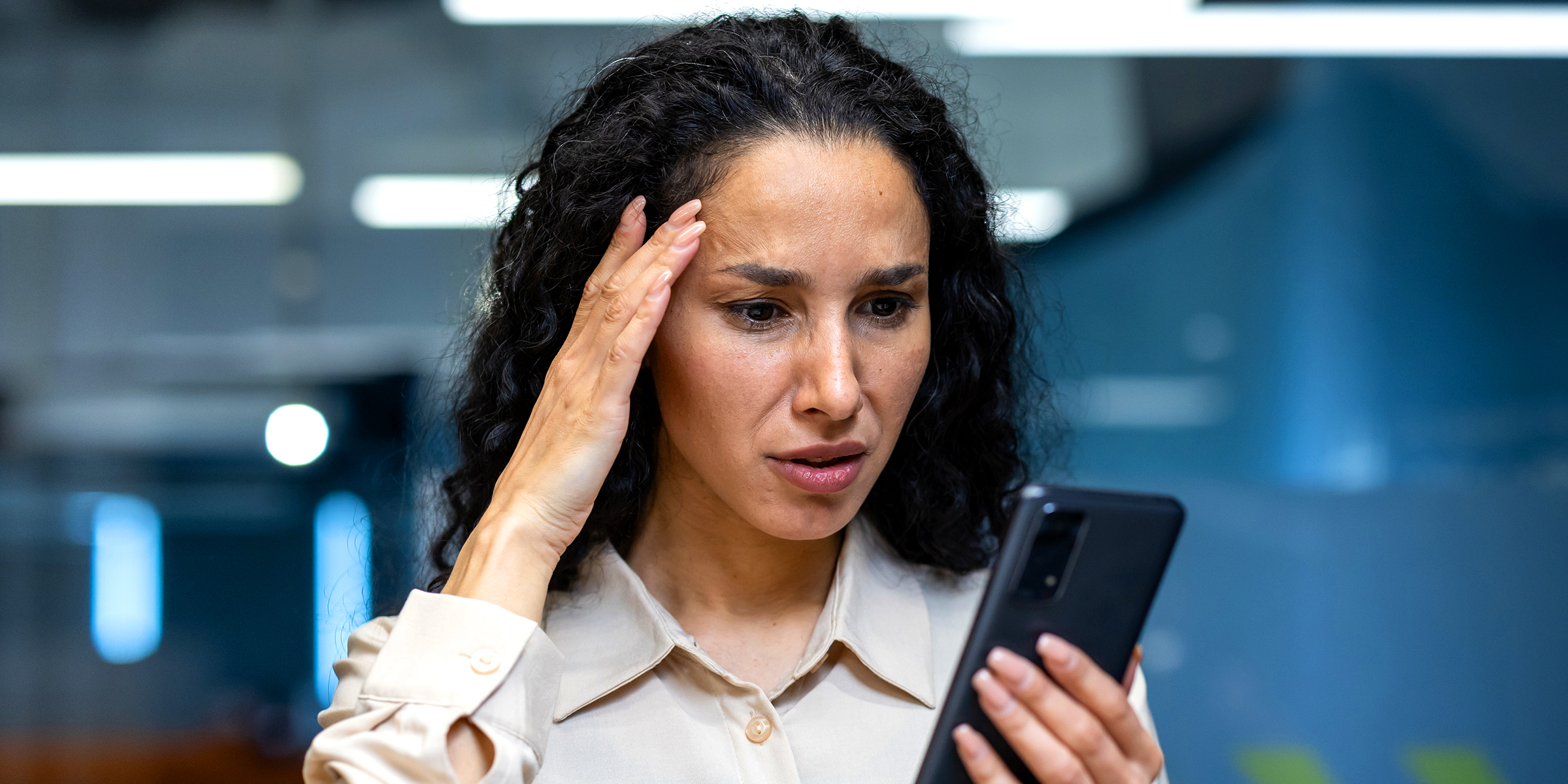 A woman looking at her phone | Source: Shutterstock