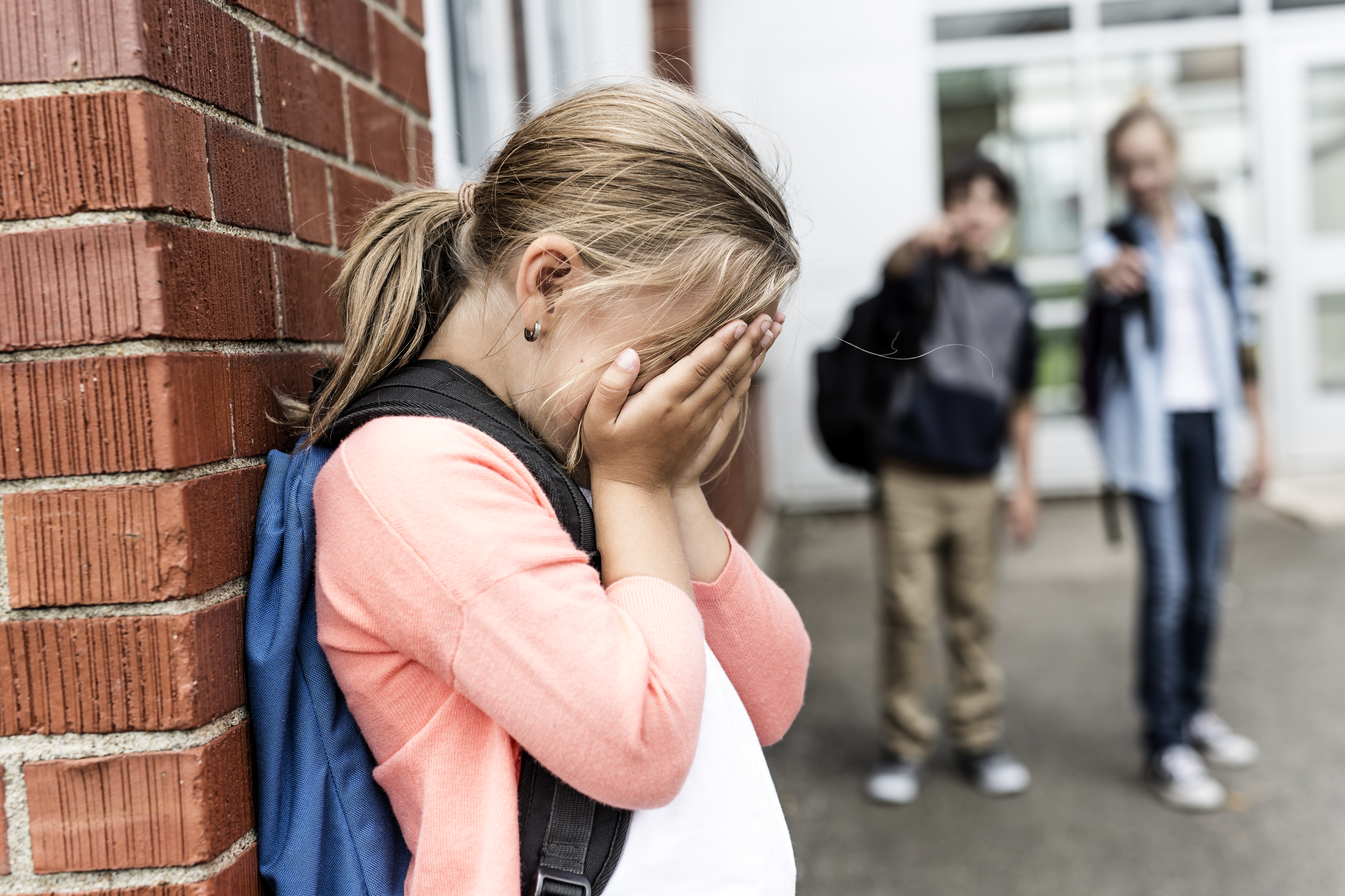 A girl crying in the school hallway | Source: Shutterstock