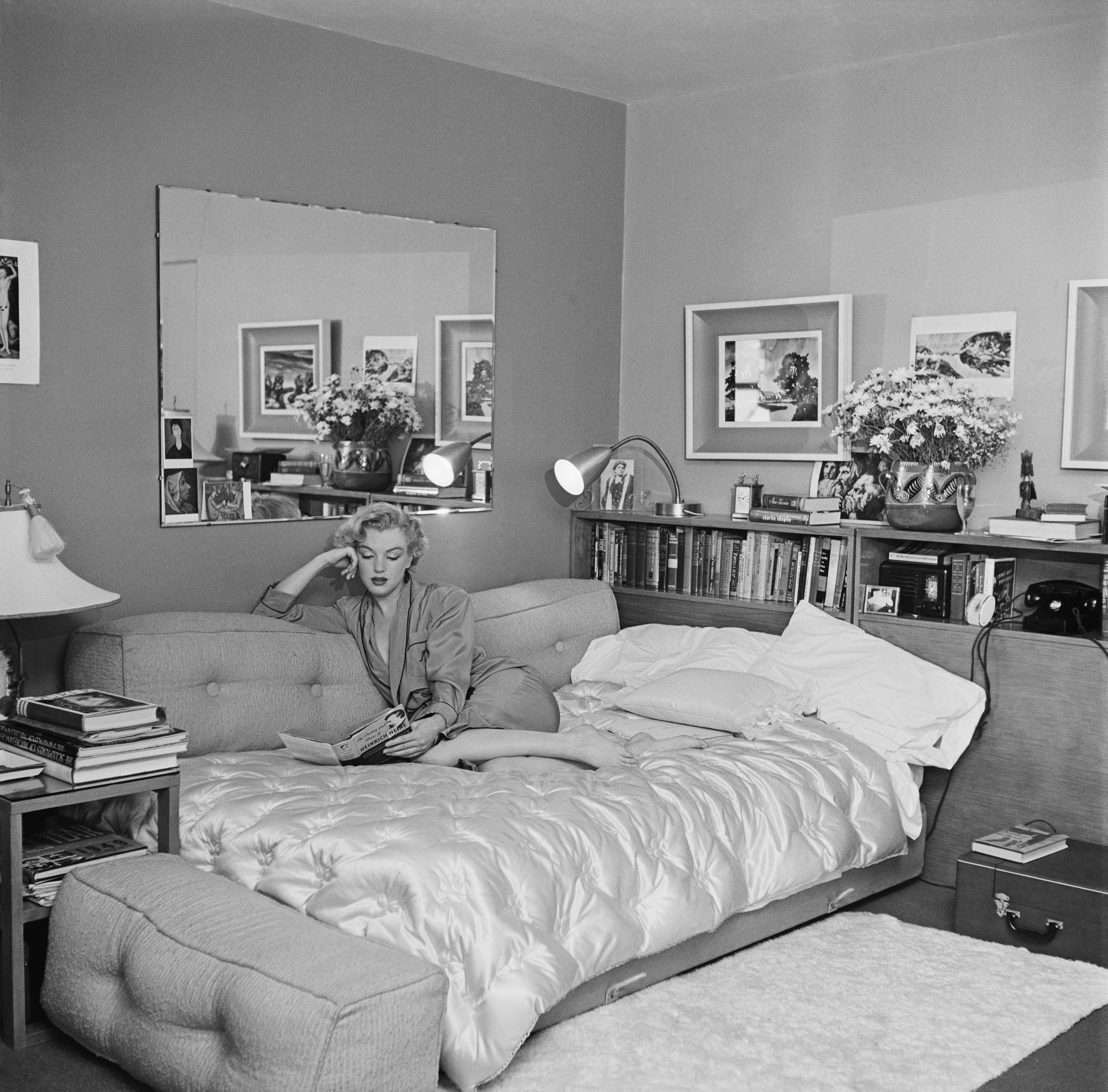 Marilyn Monroe photographed relaxing and reading a book on a sofa bed in 1951. | Source: Getty Images