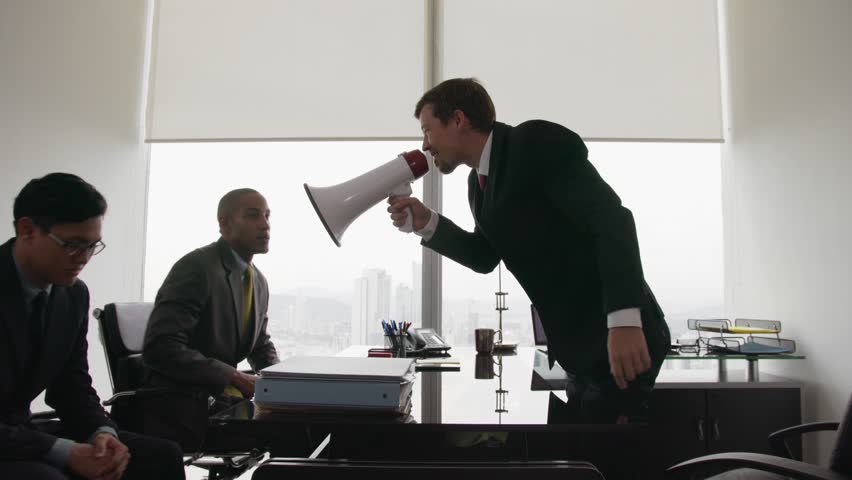 Photo of a boss holding a megaphone and yelling at his employees | Source: Shutterstock