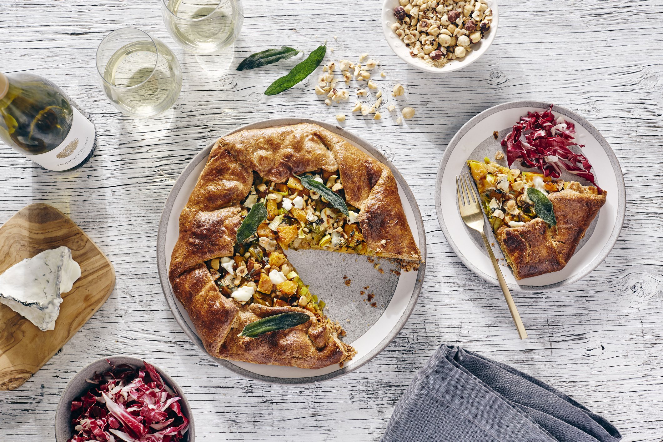 Galette et vin blanc sur table en bois blanc. | Photo : Getty Images