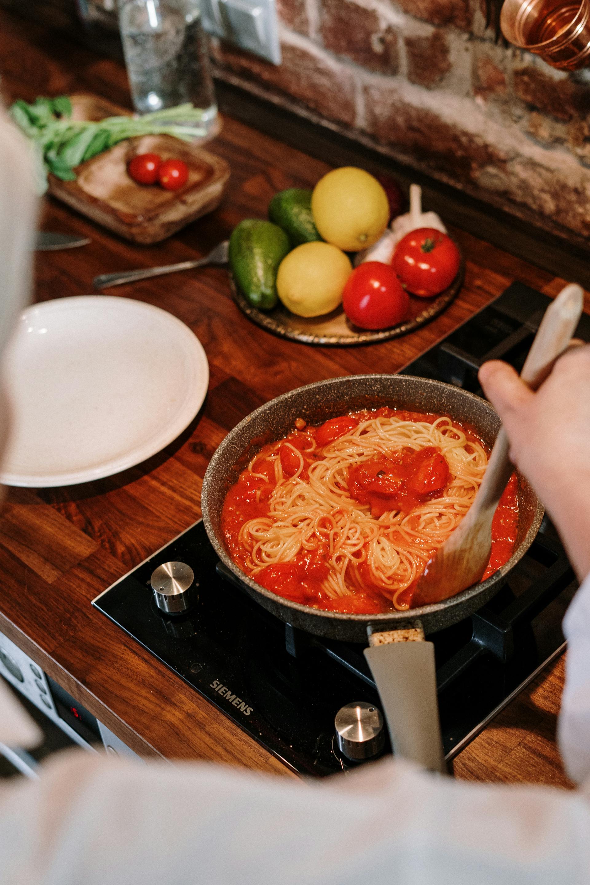 A closeup shot of a woman stirring a pot in the kitchen | Source: Pexels