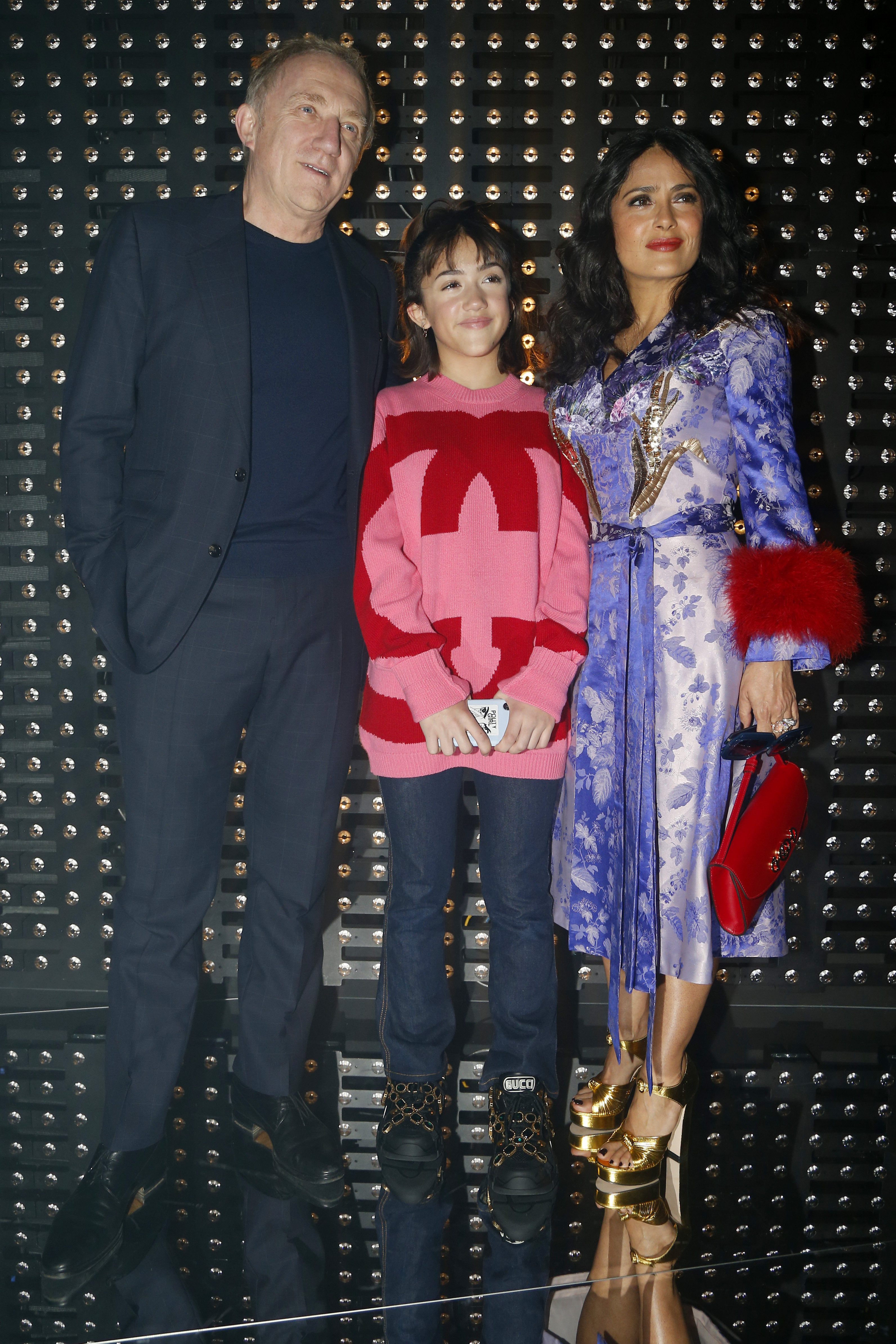 Front and center at the Gucci Fall/Winter 2019 show in Milan, Valentina Pinault joins her parents, Salma Hayek and François-Henri Pinault. Salma dazzles in a purple and gold dress with statement accessories, while Valentina wears a bold red and pink oversized sweater and jeans, standing confidently between her parents.