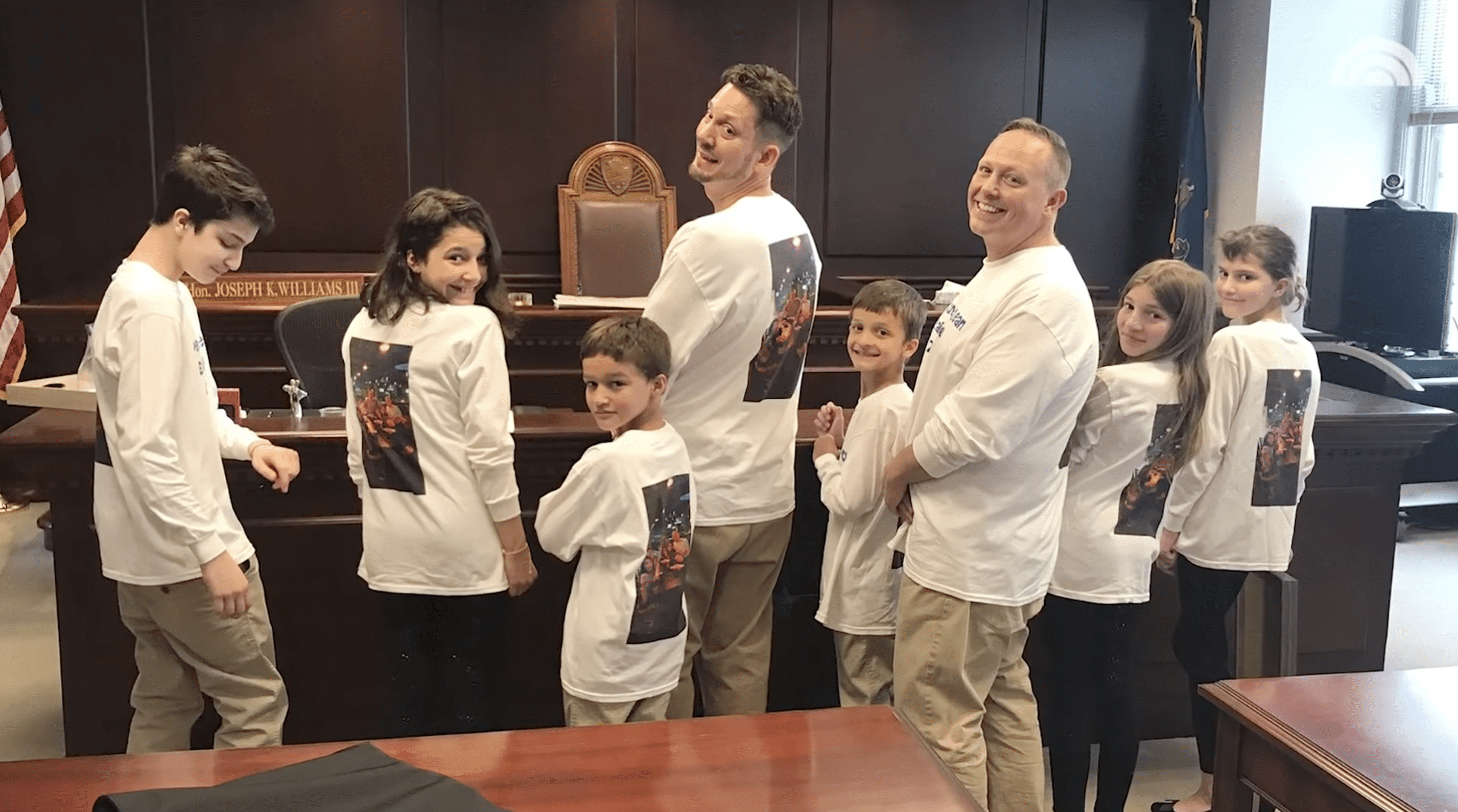 Steve and Rob pictured in their matching white t-shirts with the six siblings on adoption day. | Photo: YouTube.com/TODAY