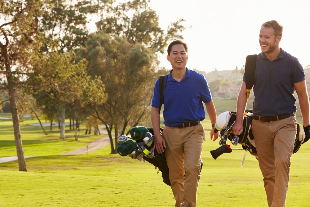 Two male golfers walking along the golf course. | Photo: Shutterstock