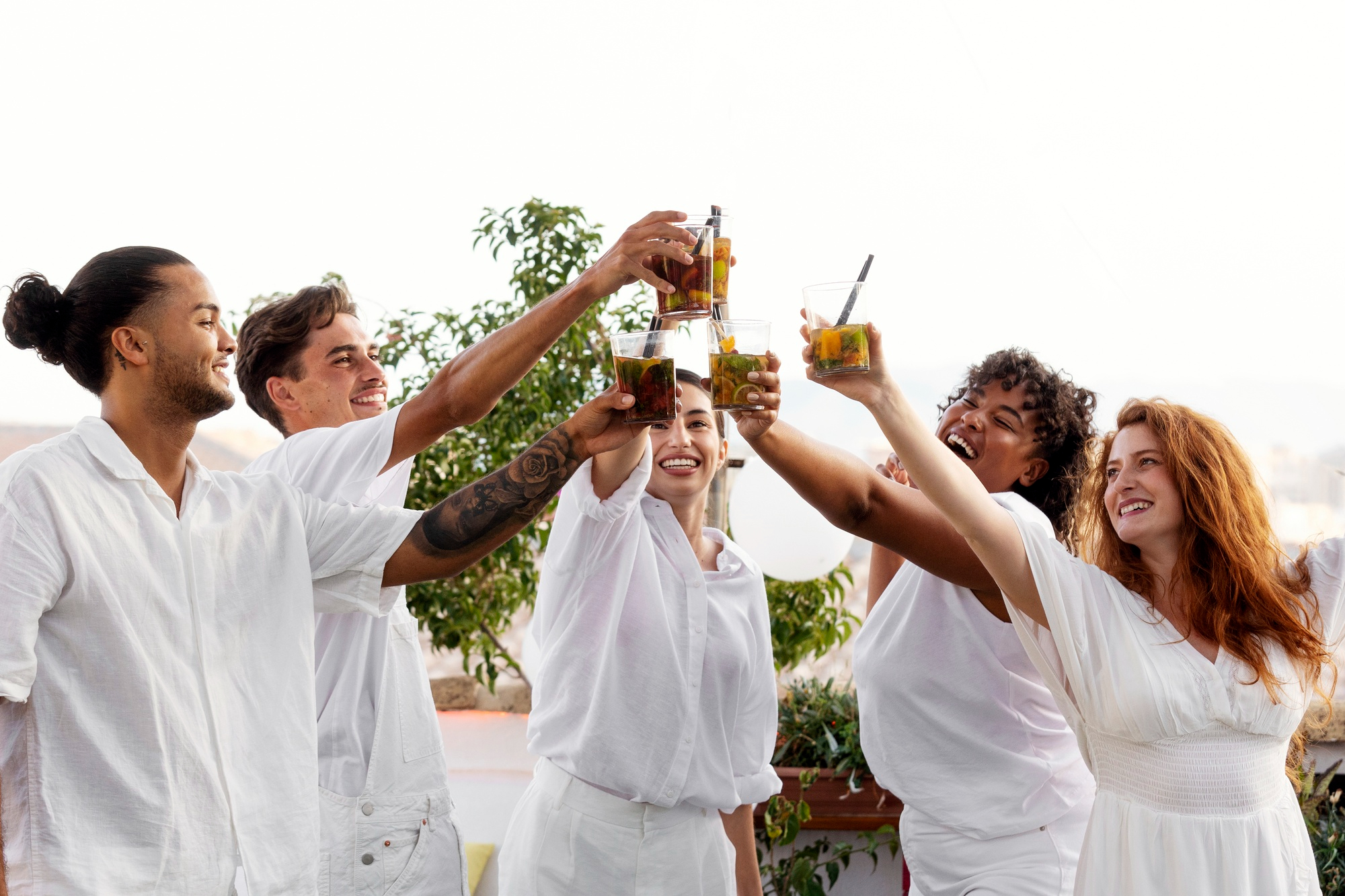 People having a toast at an all-white party | Source: Freepik
