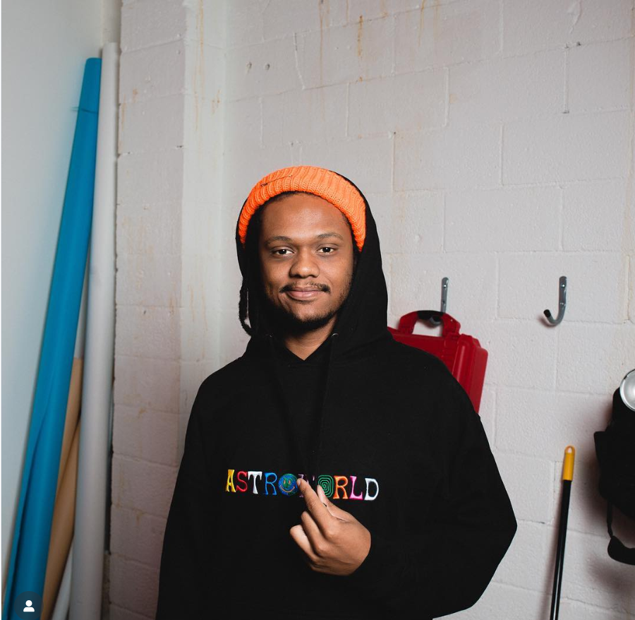 Niko McKnight stands indoors wearing an orange knit beanie and a black hoodie with the word “ASTROWORLD” printed across the chest in colorful lettering, from a post dated September 15, 2018. | Source: Instagram/fiftyclicks