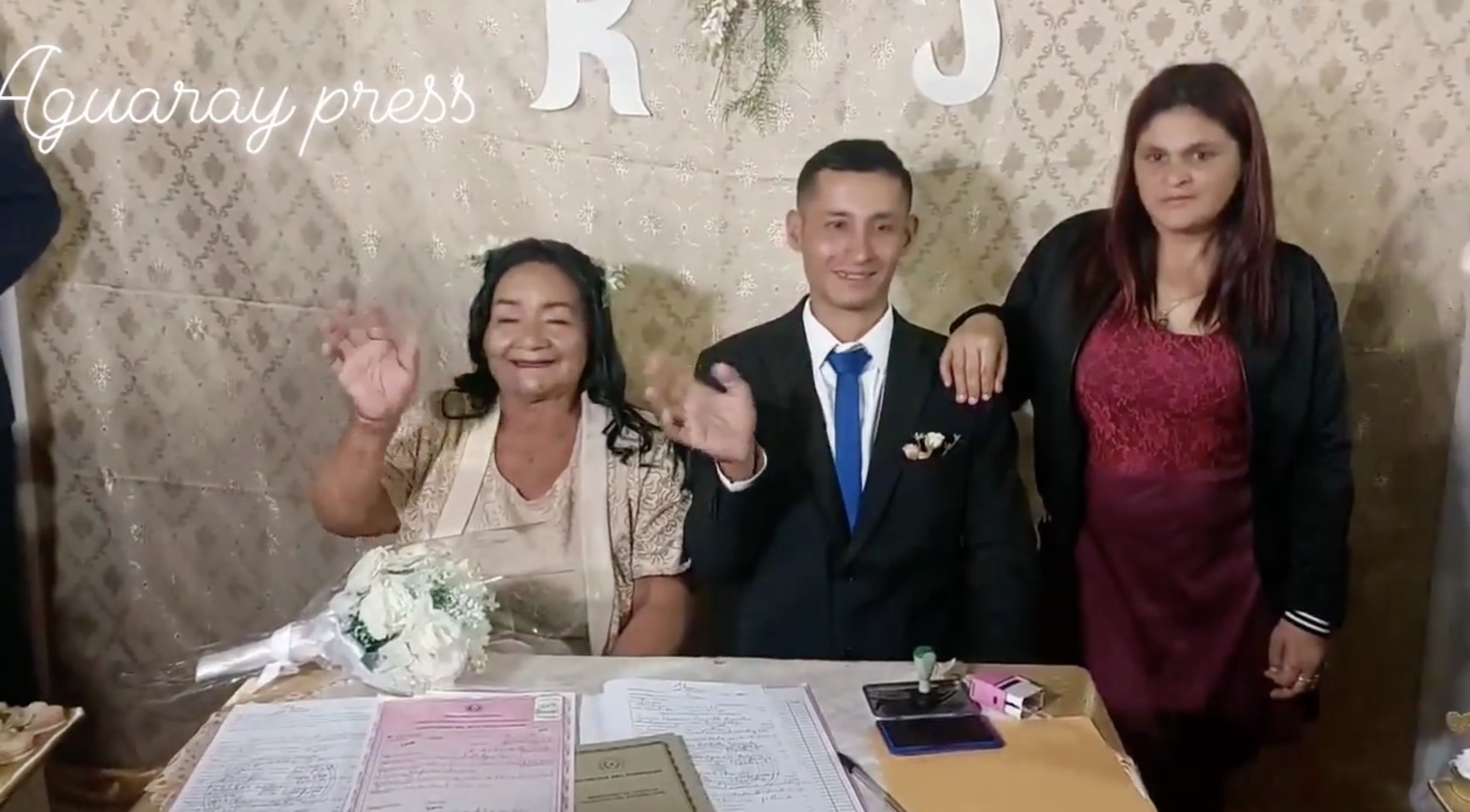 Rufina Ibarra und Juan Portillo lächeln und winken den Gästen zu, während sie an ihrem Hochzeitstisch sitzen | Quelle: facebook.com/Aguaray-Press