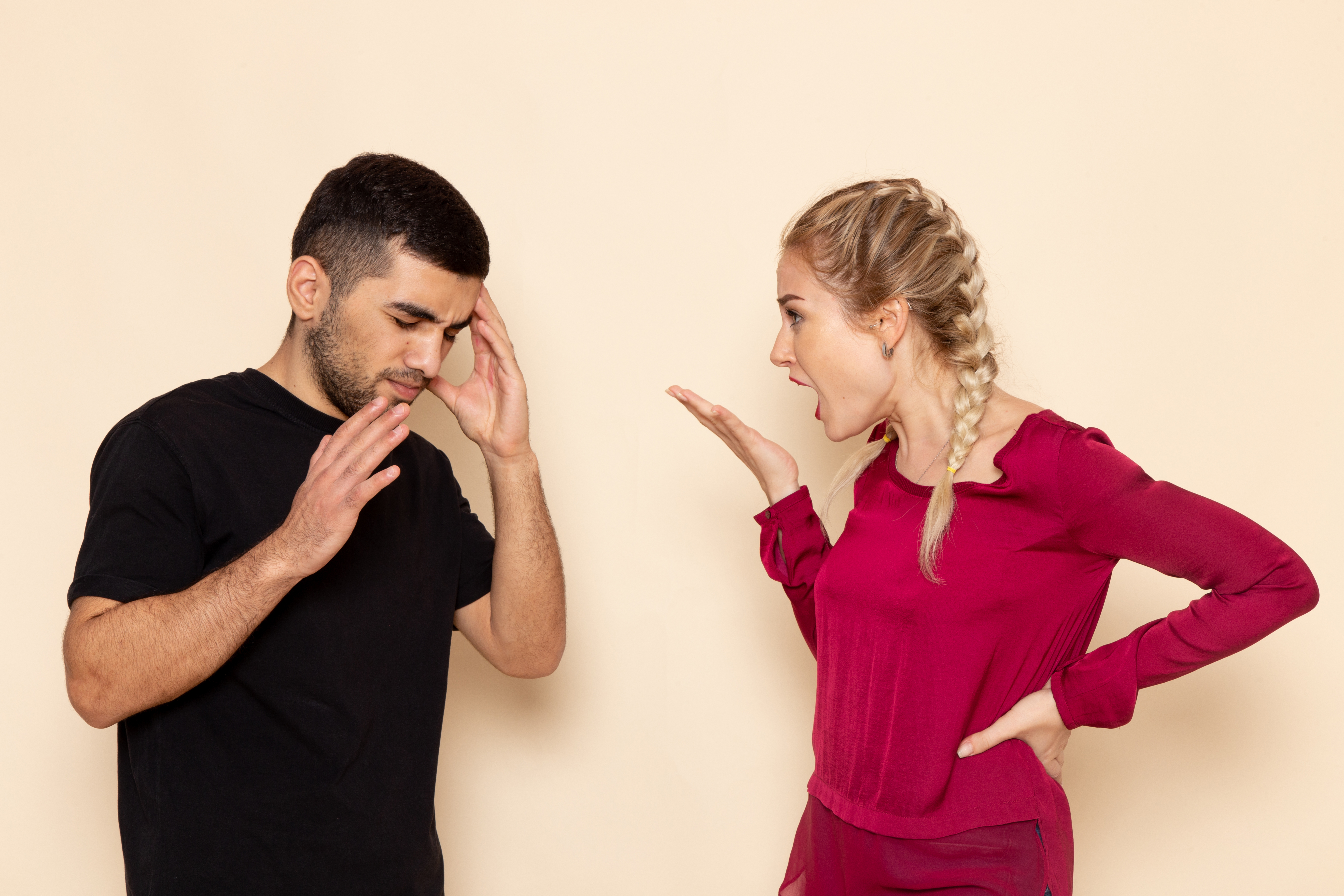Woman gesturing to a man who looks confused | Source: Freepik