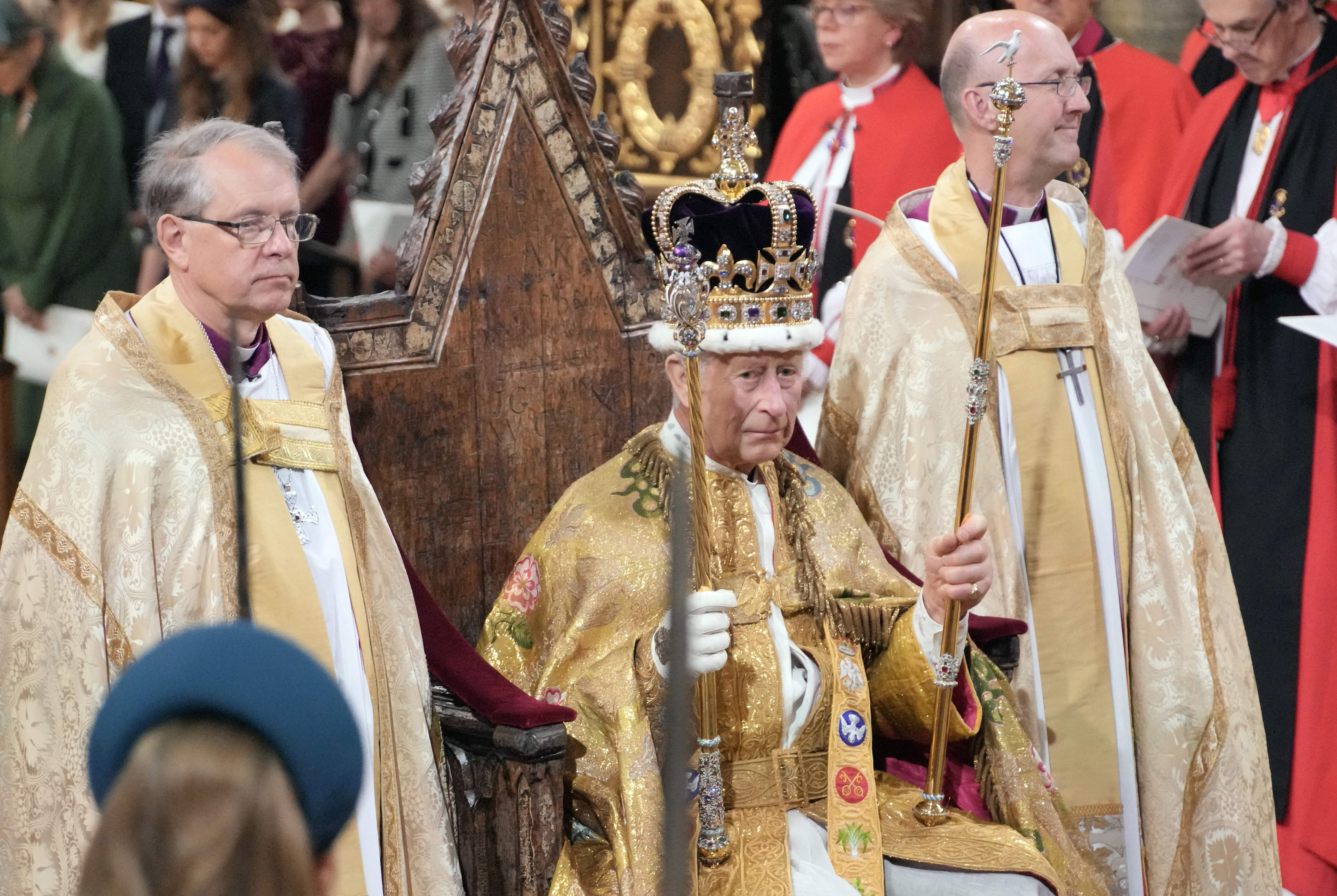 King Charles III sitting on his throne wearing St. Edward's crown during his Coronation ceremony inside Westminster Abbey on May 6, 2023 | Source: Getty Images