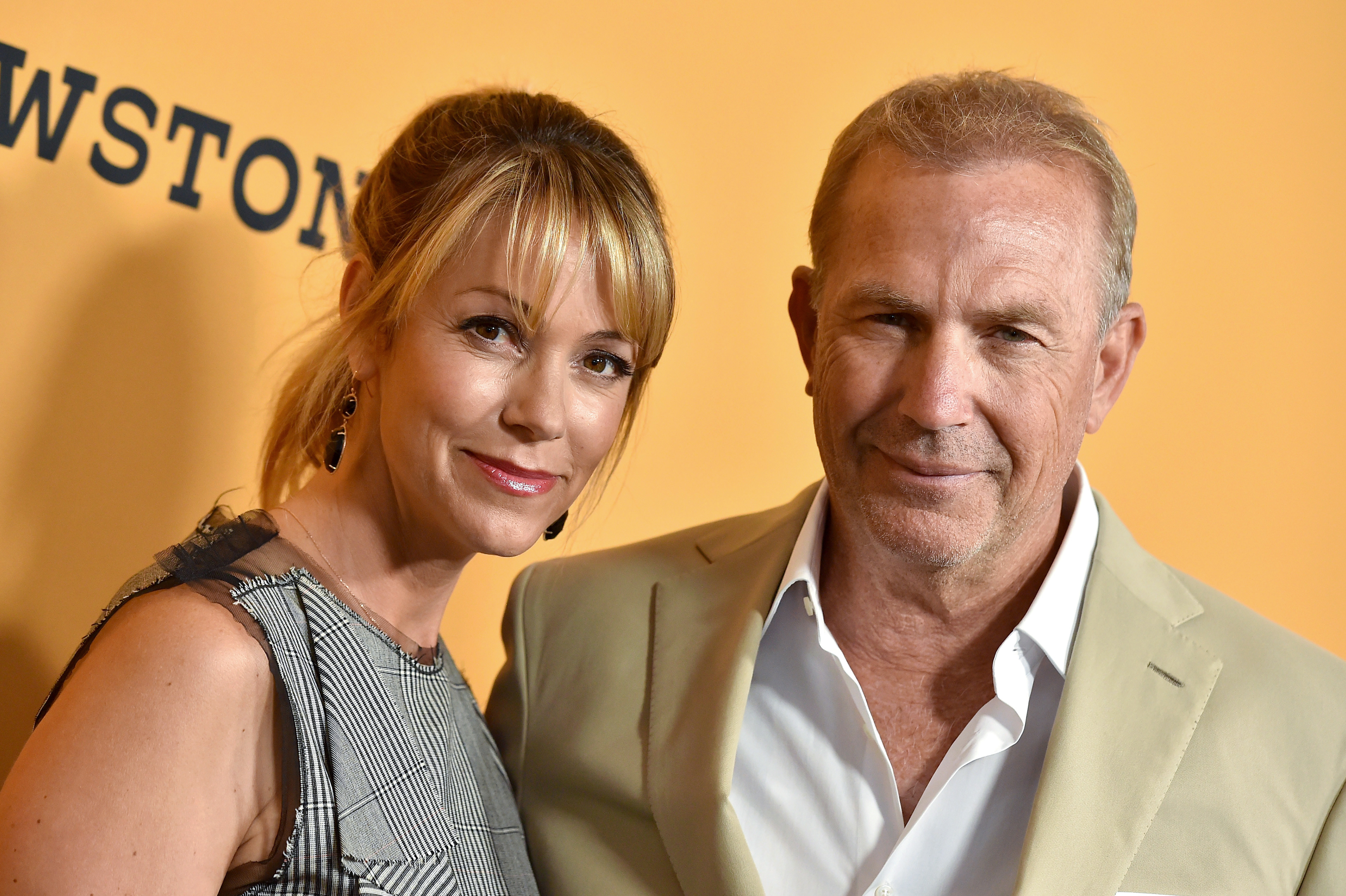 Christine Baumgartner and Kevin Costner leaned in close at the "Yellowstone" premiere, their soft smiles and warm expressions reflecting years of shared history. Baumgartner wore a textured, sleeveless dress while Costner kept it sharp in a beige suit, both looking effortlessly in sync.