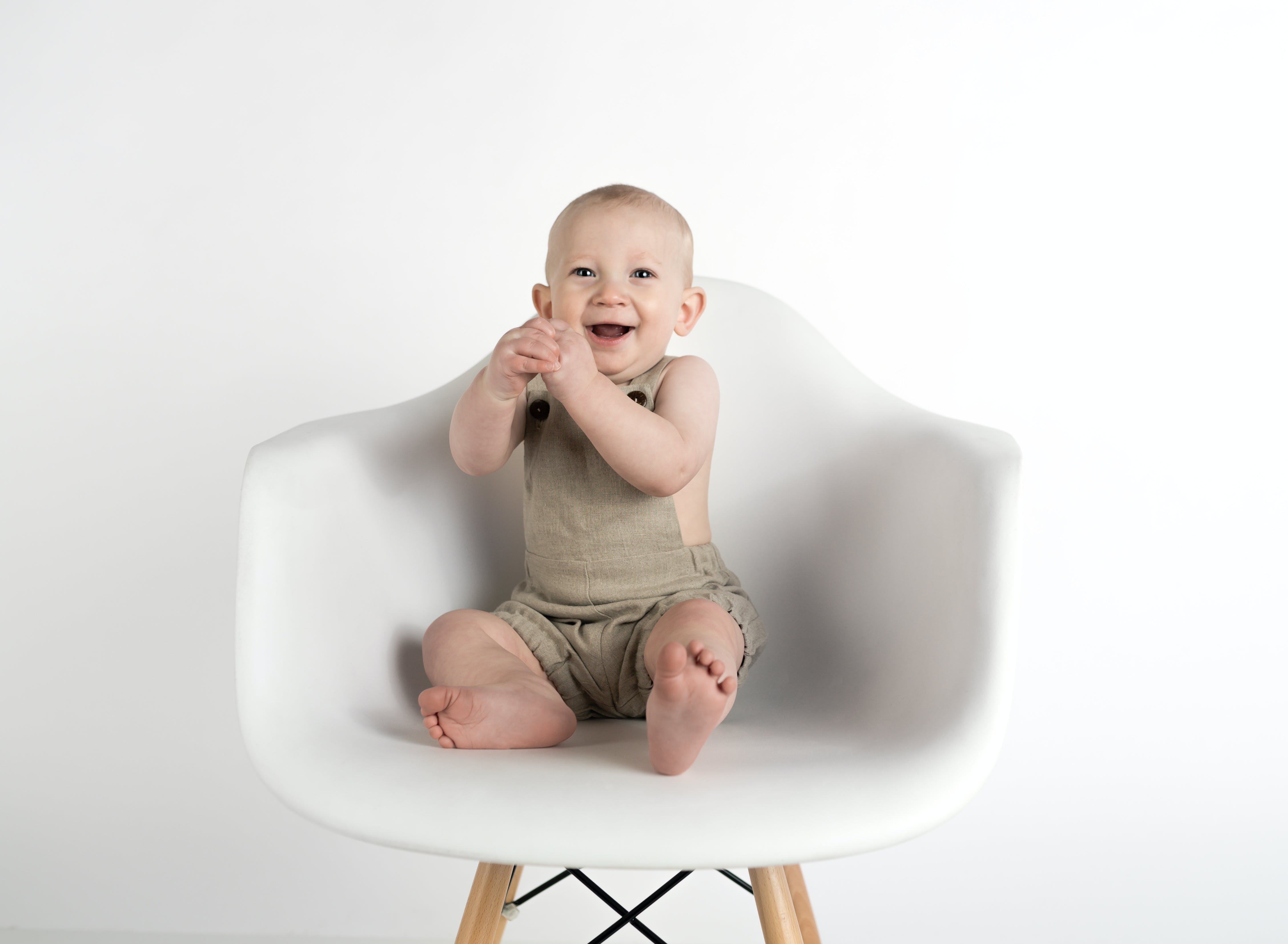A baby laughing while seated on a chair | Source: Pexels