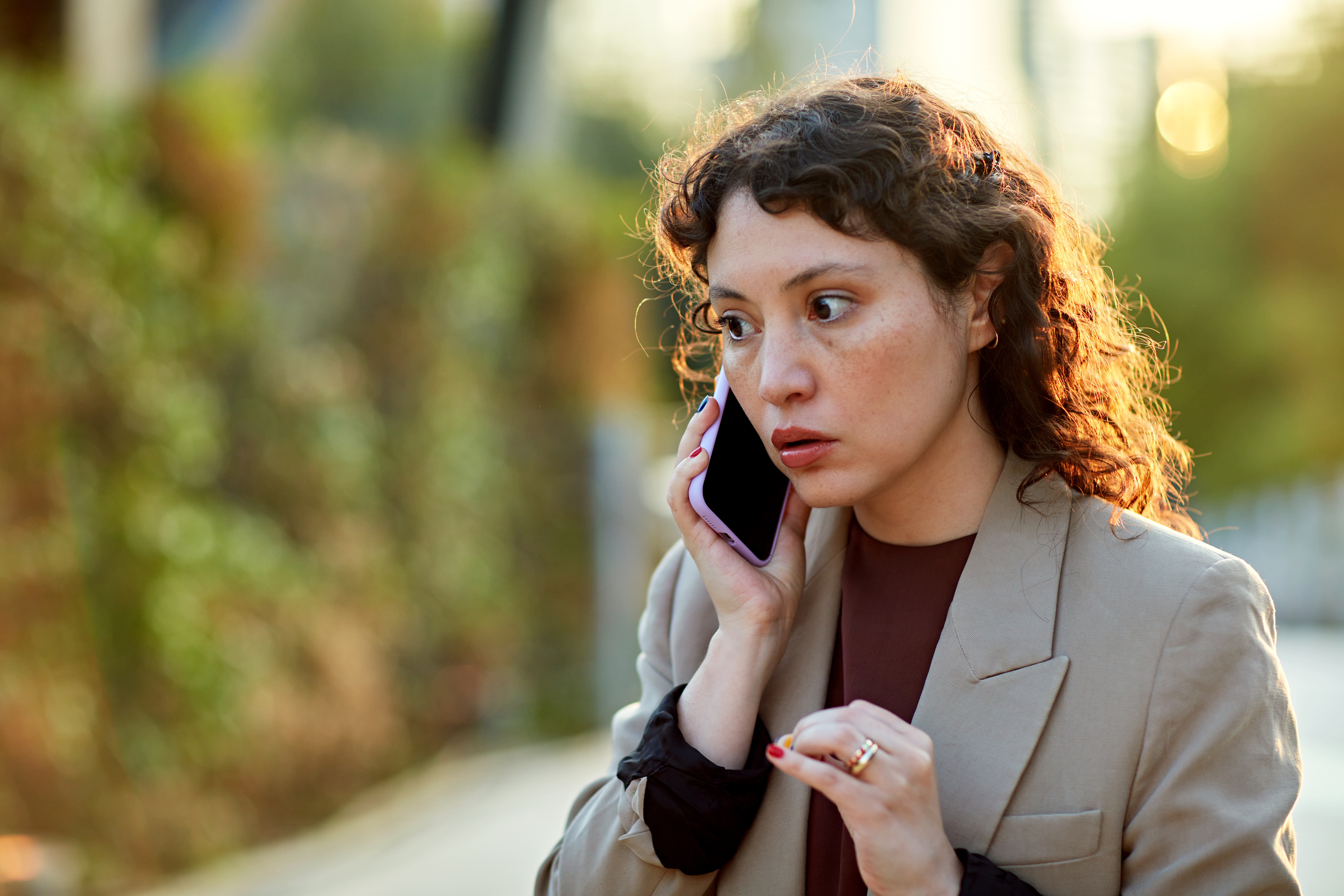 Concerned businesswoman using phone outdoors | Source: Getty Images