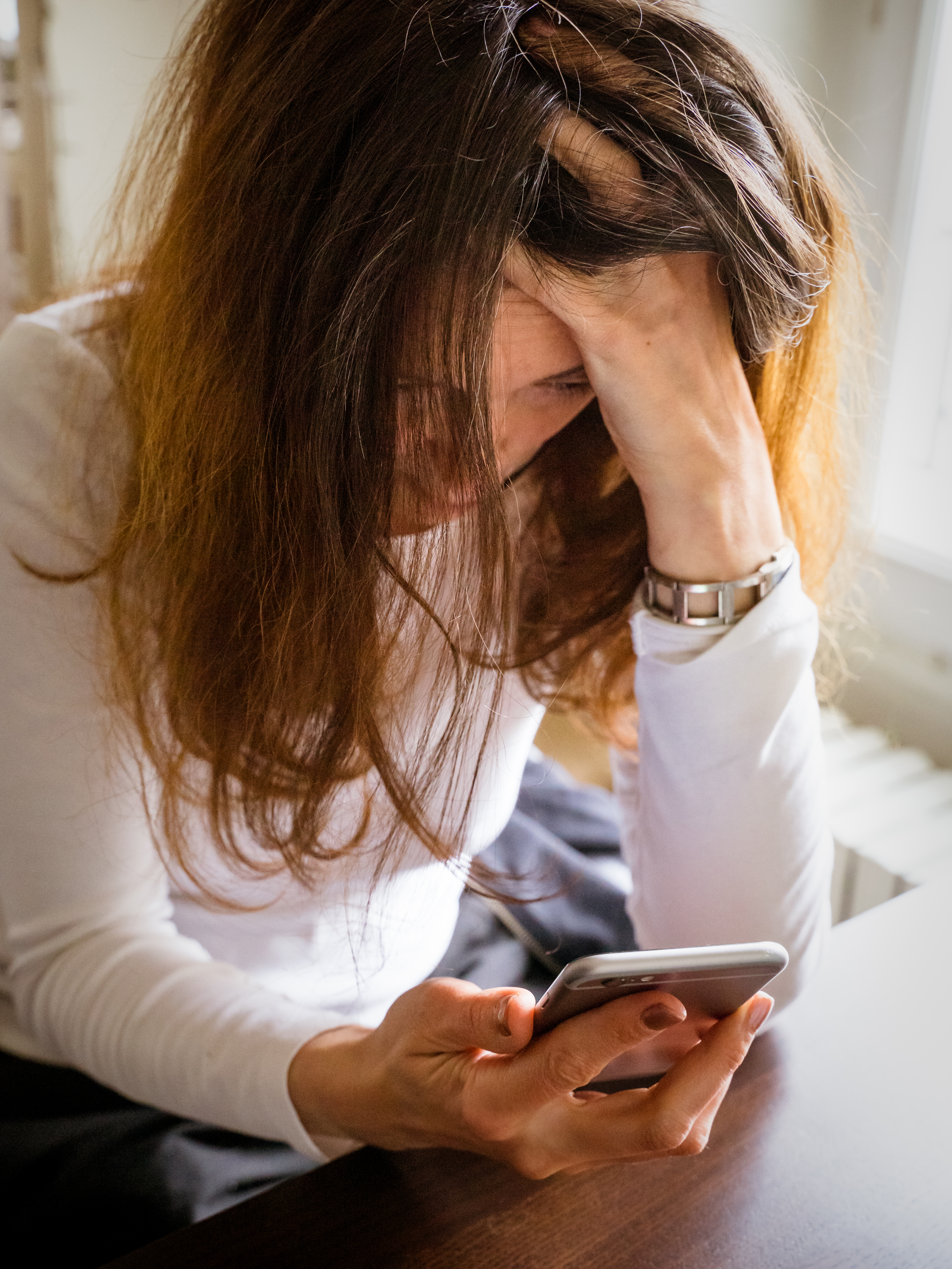 An upset woman looking at her phone | Source: Getty Images