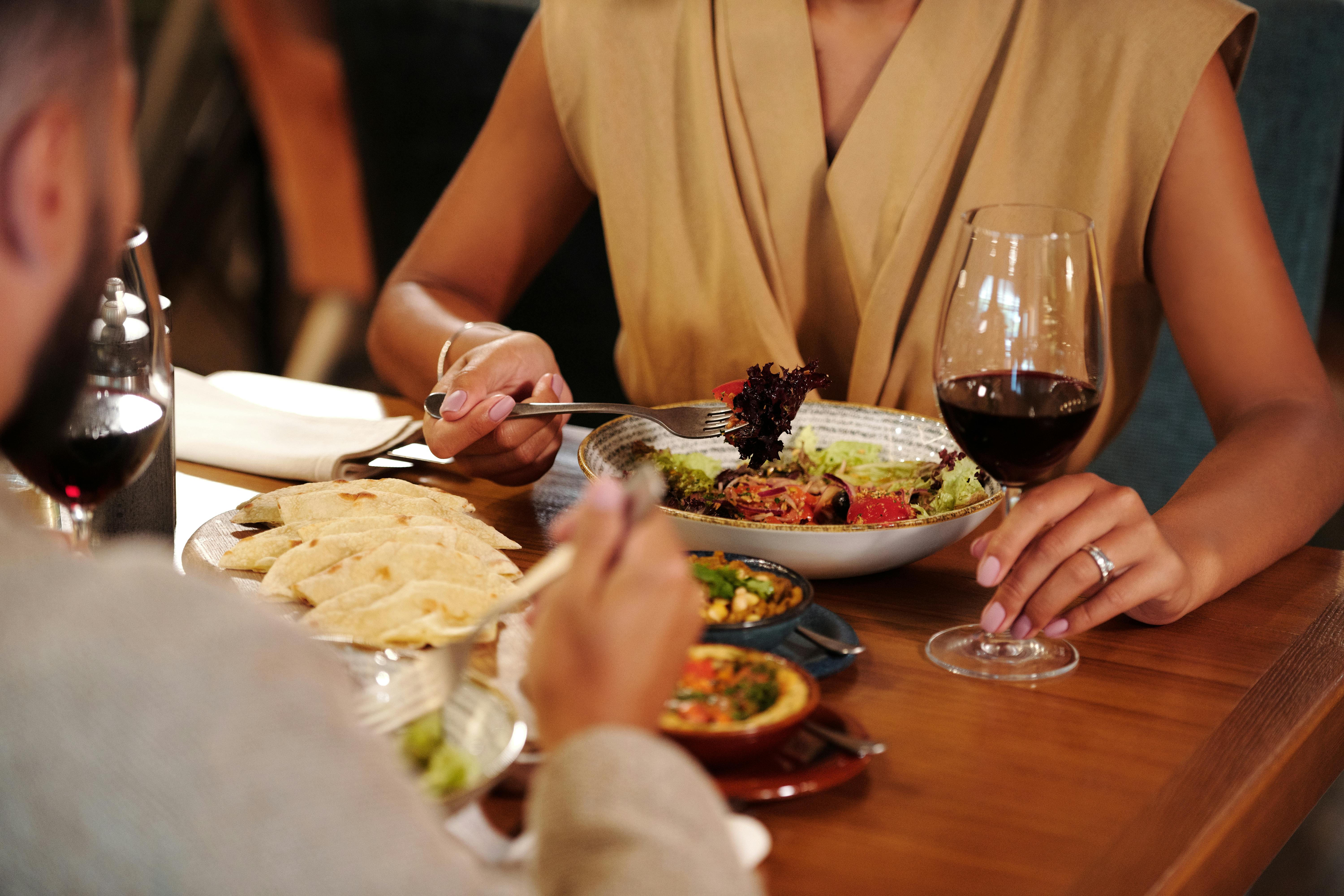 People enjoying a meal and drinks | Source: Pexels