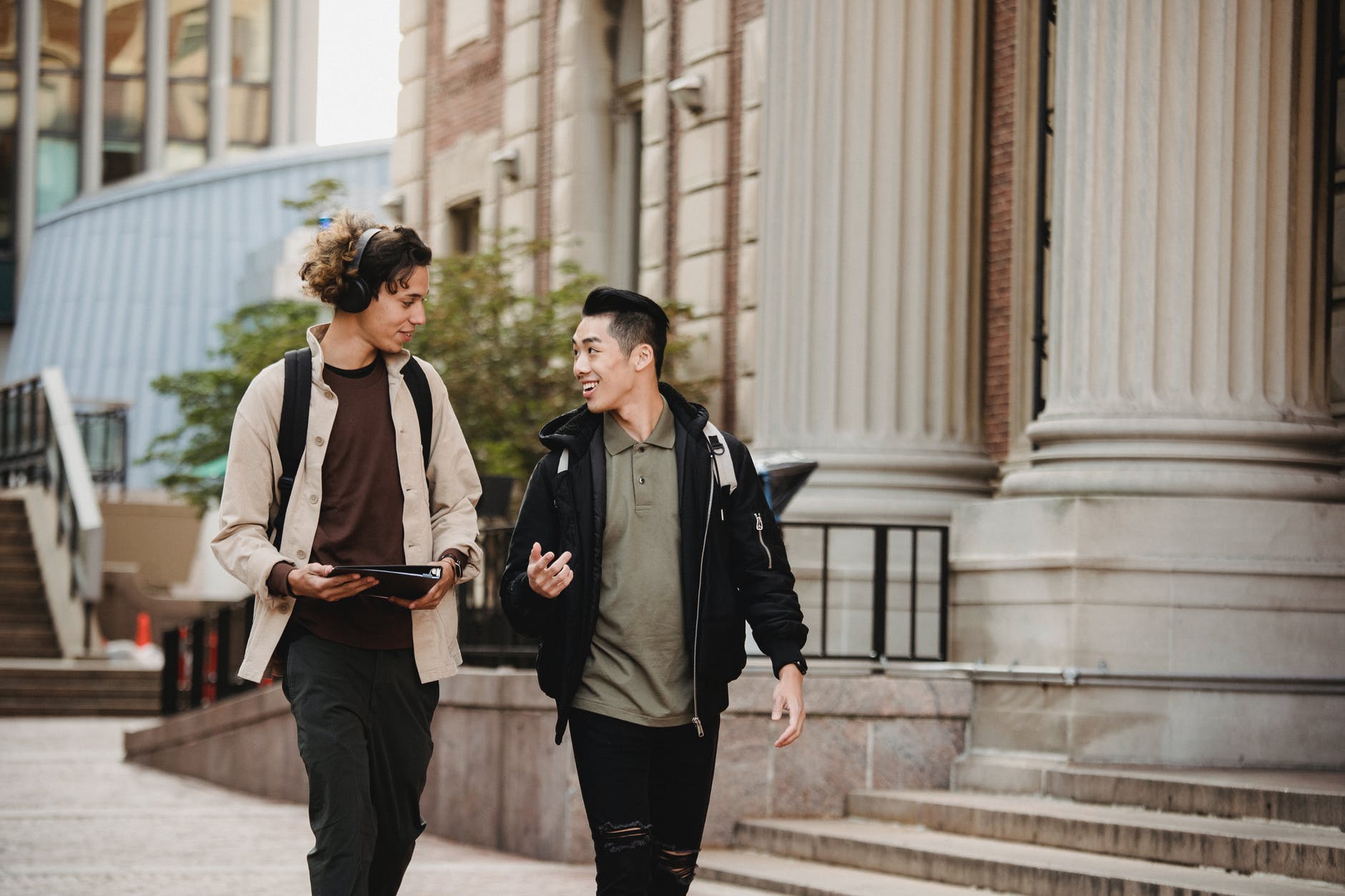 Two students talking and walking around campus | Source: Pexels