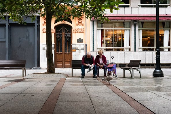 Un couple de personnes âgées est assis sur un banc de la ville, seul, en regardant une mouette. |Photo : Getty Images.