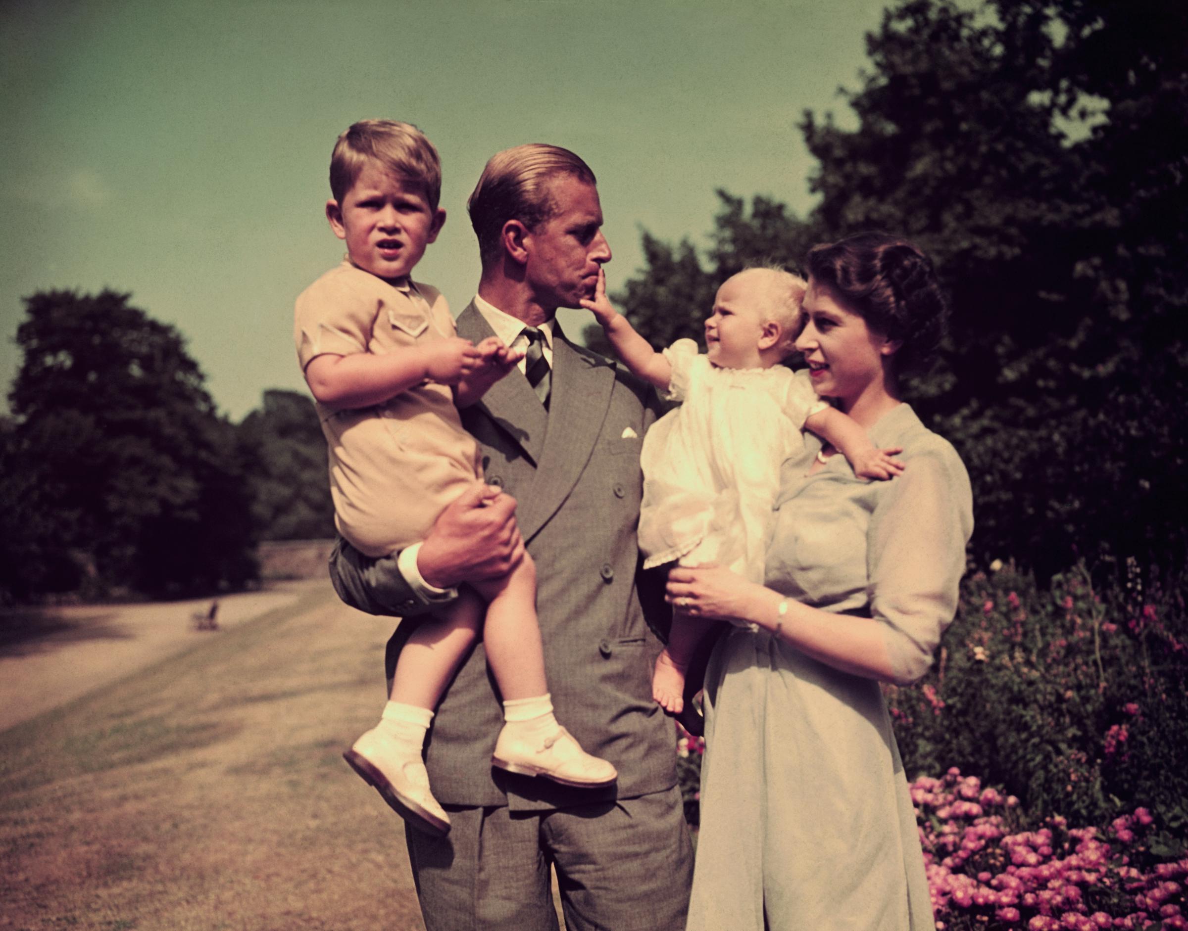 Prince Philip, Duke of Edinburgh, and Queen Elizabeth II holding their children, King Charles III, and Princess Anne, circa 1951. | Source: Getty Images