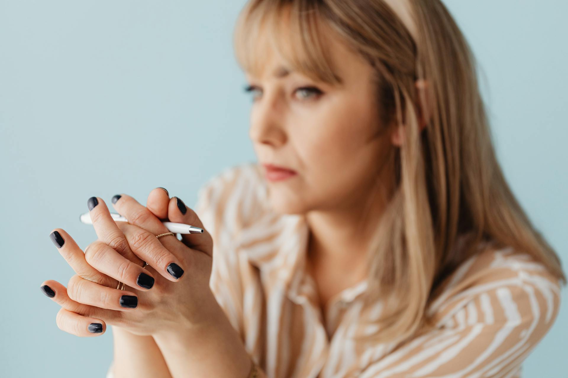 A woman holding a white pen | Source: Pexels