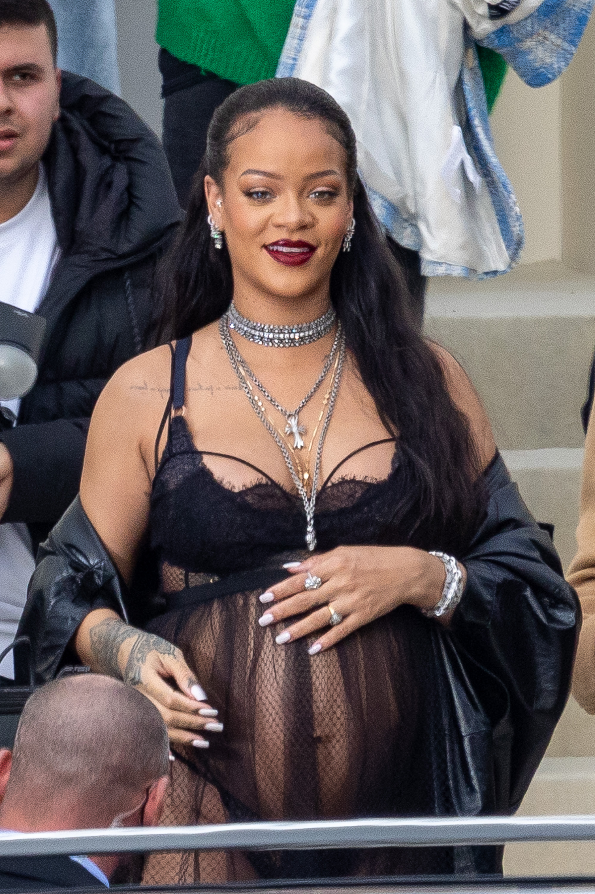 Arriving at Dior's Fall/Winter Womenswear show with magnetic poise, Rihanna's sheer black look boldly frames her radiant maternity style. Sparkling diamonds cascade across her neckline, adding unmistakable glamor as she embodies confidence and star power against the Parisian backdrop.