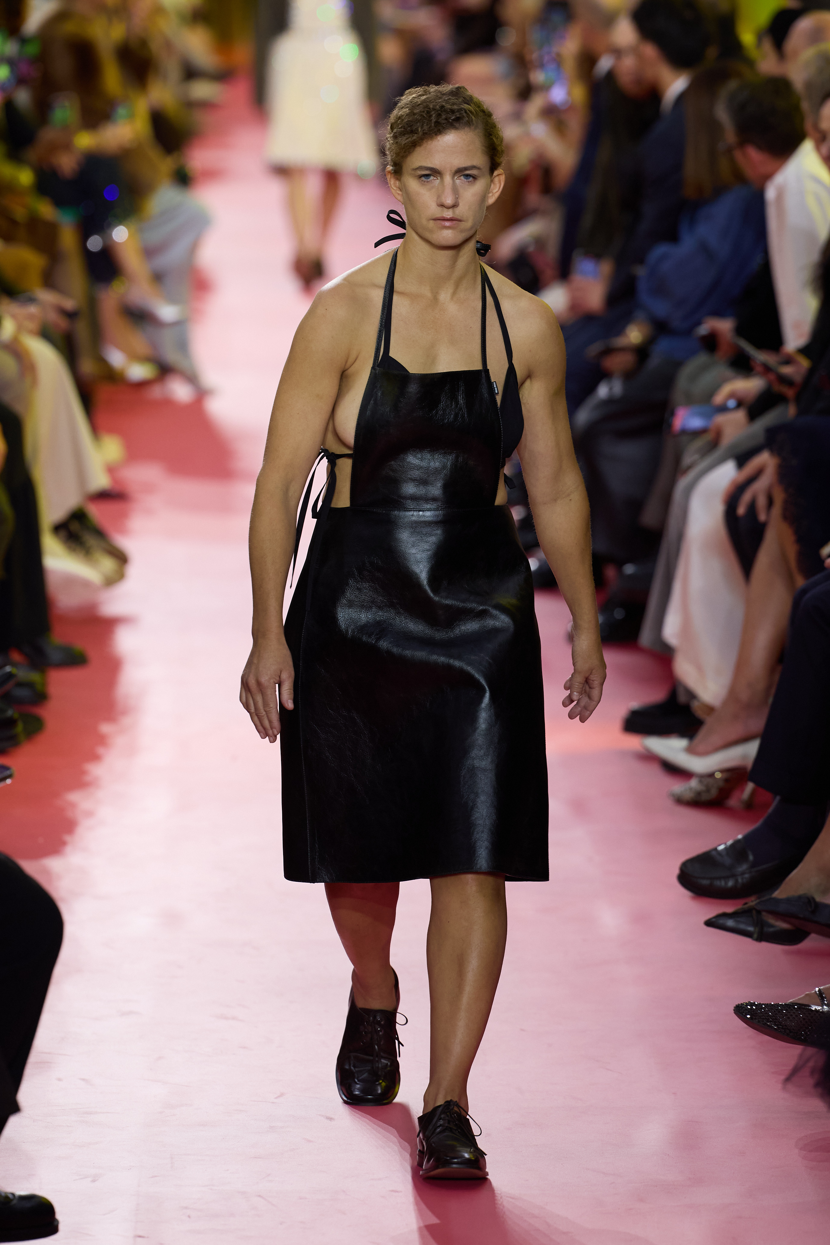 A model walks the runway during the Miu Miu Women’s Spring/Summer 2026 show at Paris Fashion Week in France. The show centered on the apron, as seen on the model in leather — a creative and striking reimagining of the classic piece.