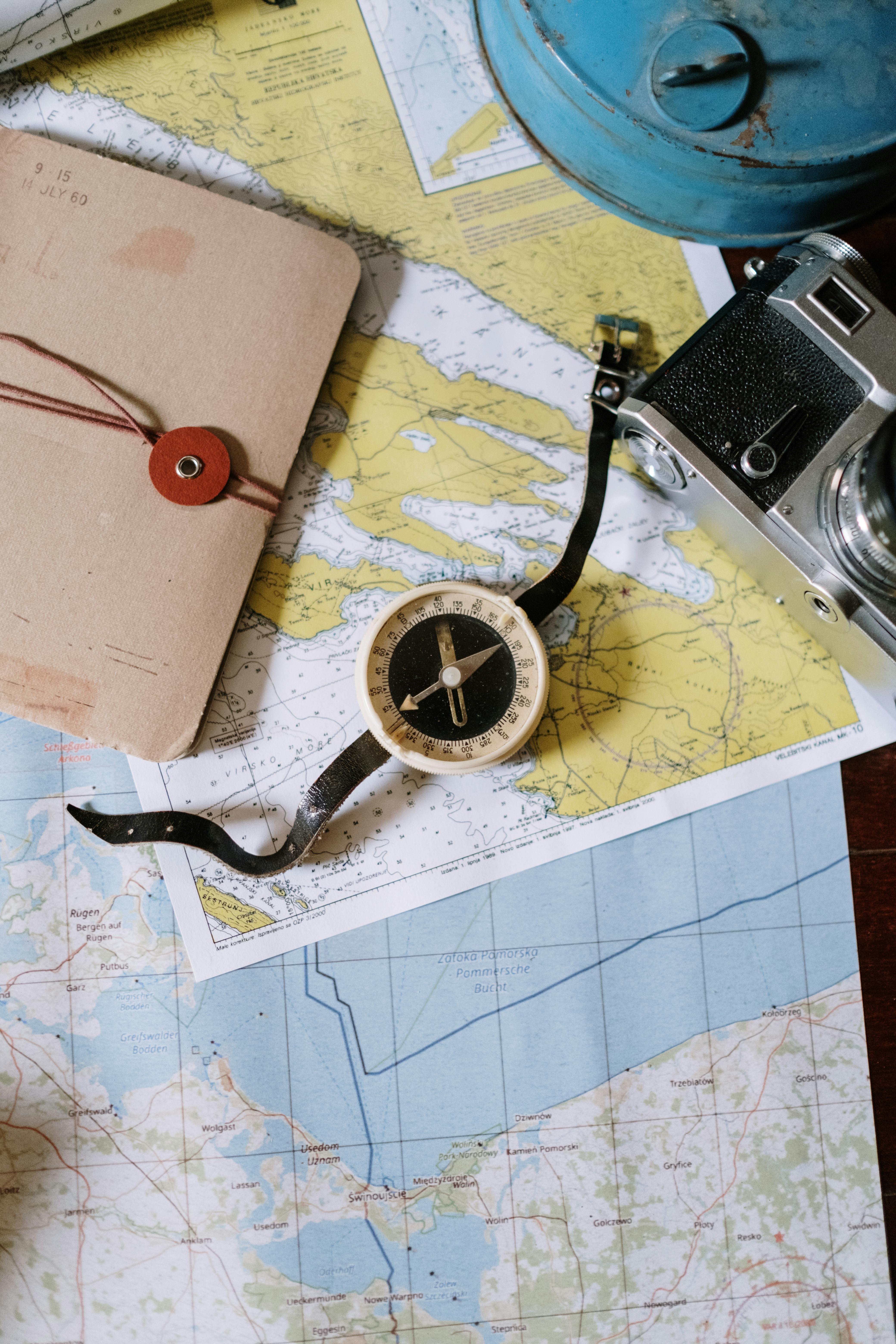 A compass and an old camera lying on a table | Source: Pexels