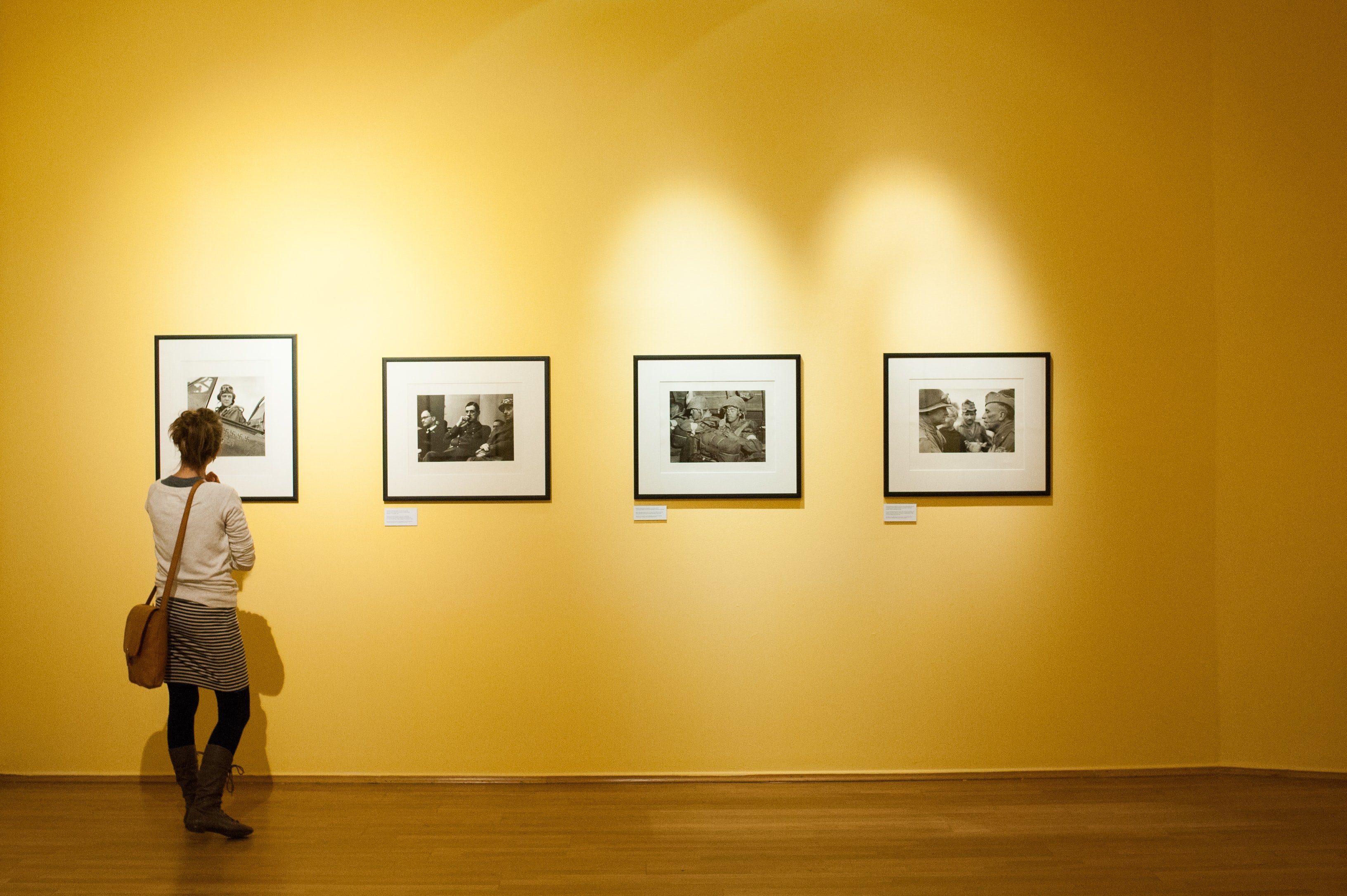 Mujer admirando una exhibición de fotografías. | Foto: Unsplash