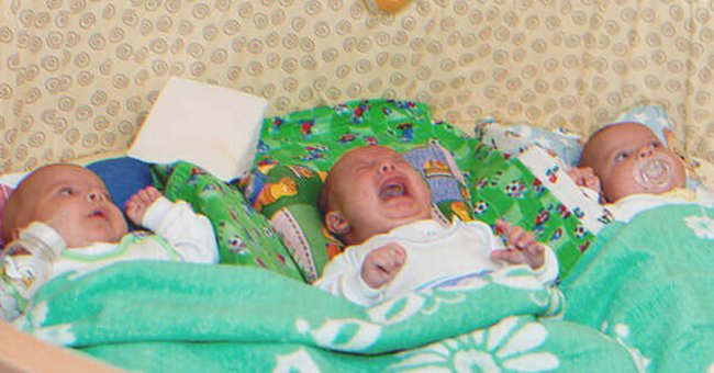 Three babies on a bed | Source: Shutterstock