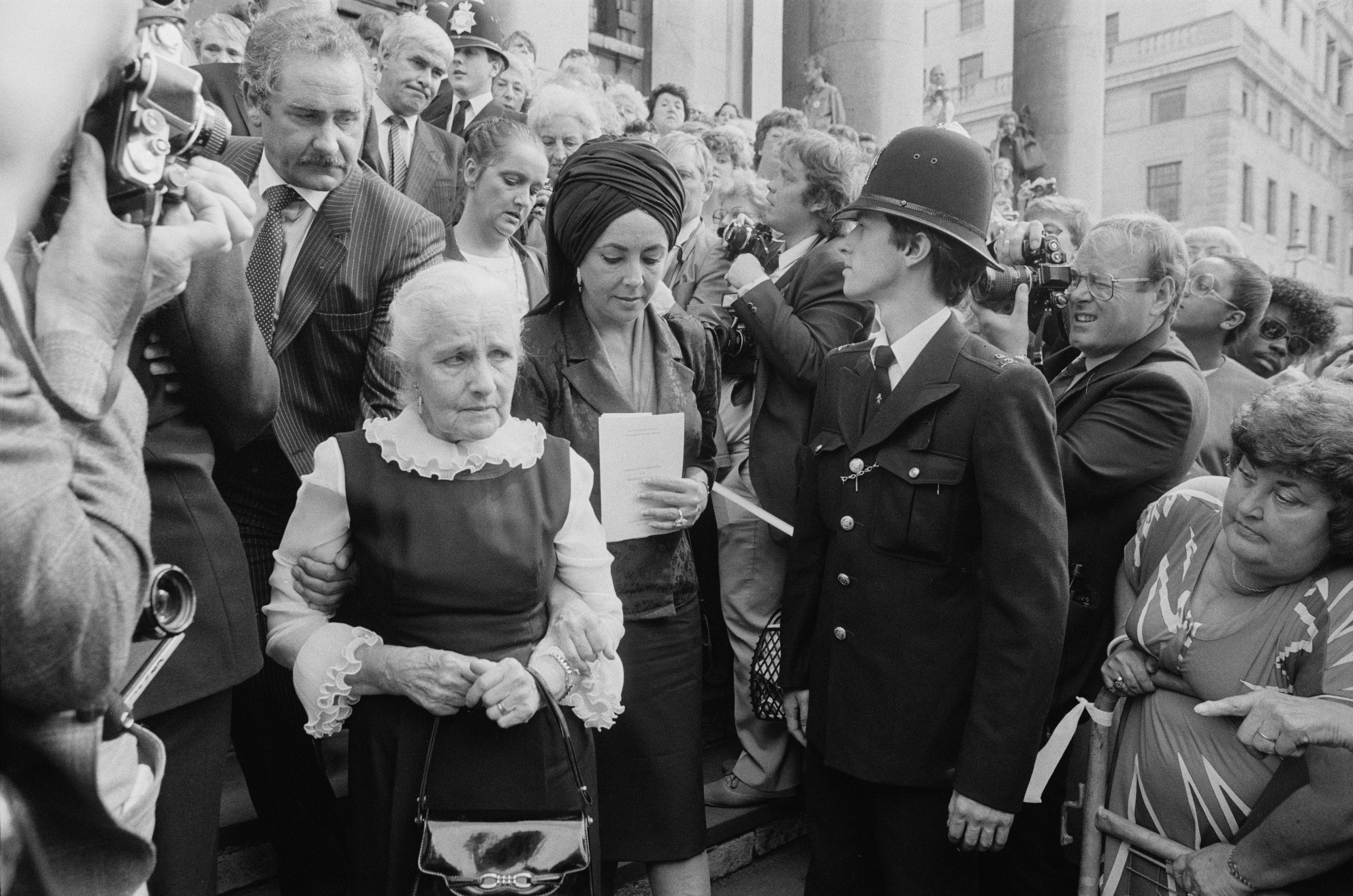 Elizabeth Taylor leaves Richard Burton's memorial service with his elderly sister on August 30, 1984, in St-Martin-in-the-Fields Church, London. | Source: Getty Images
