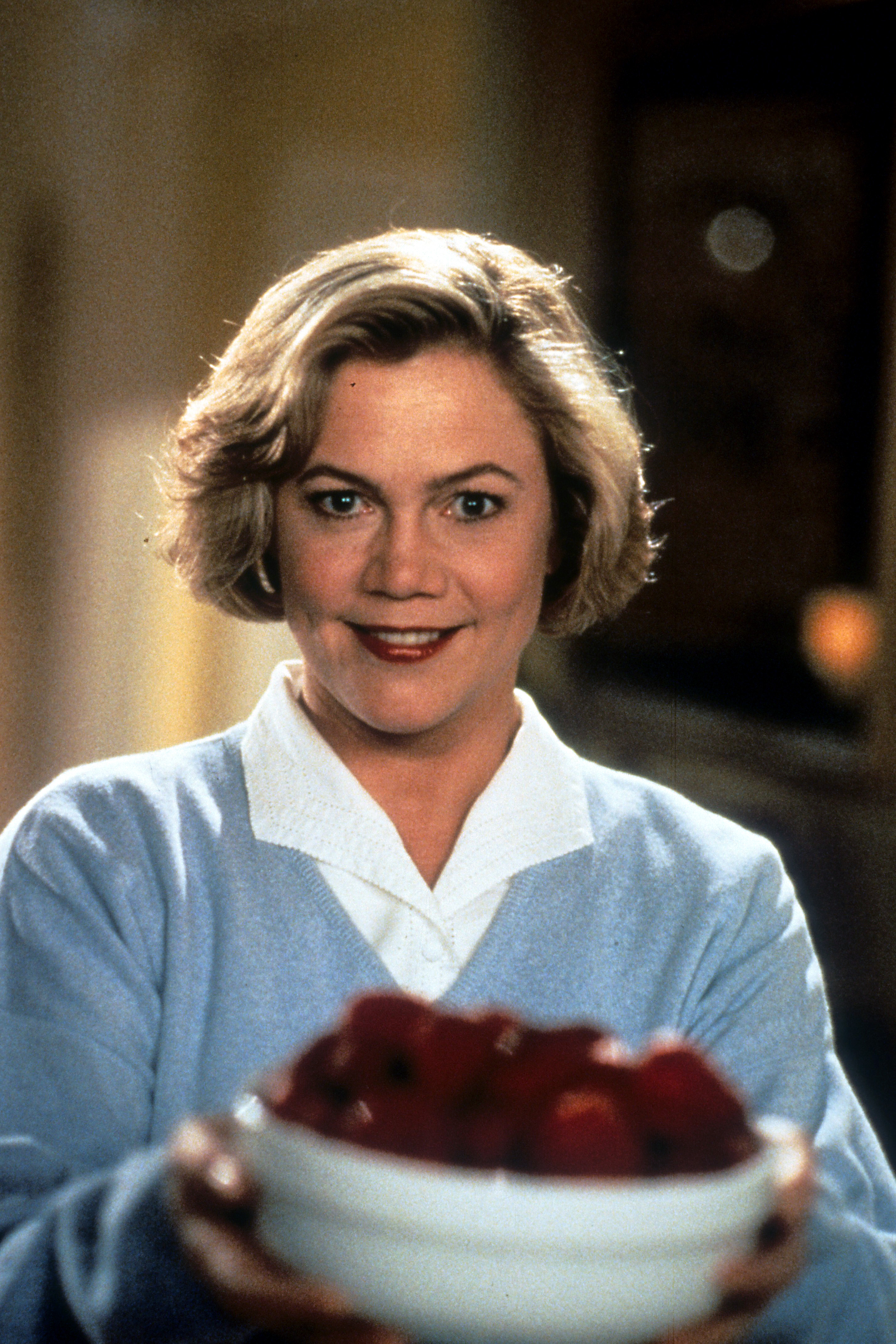 Kathleen Turner holding a bowl of fruit in a scene from the film "Serial Mom" released 1994. | Source: Getty Images