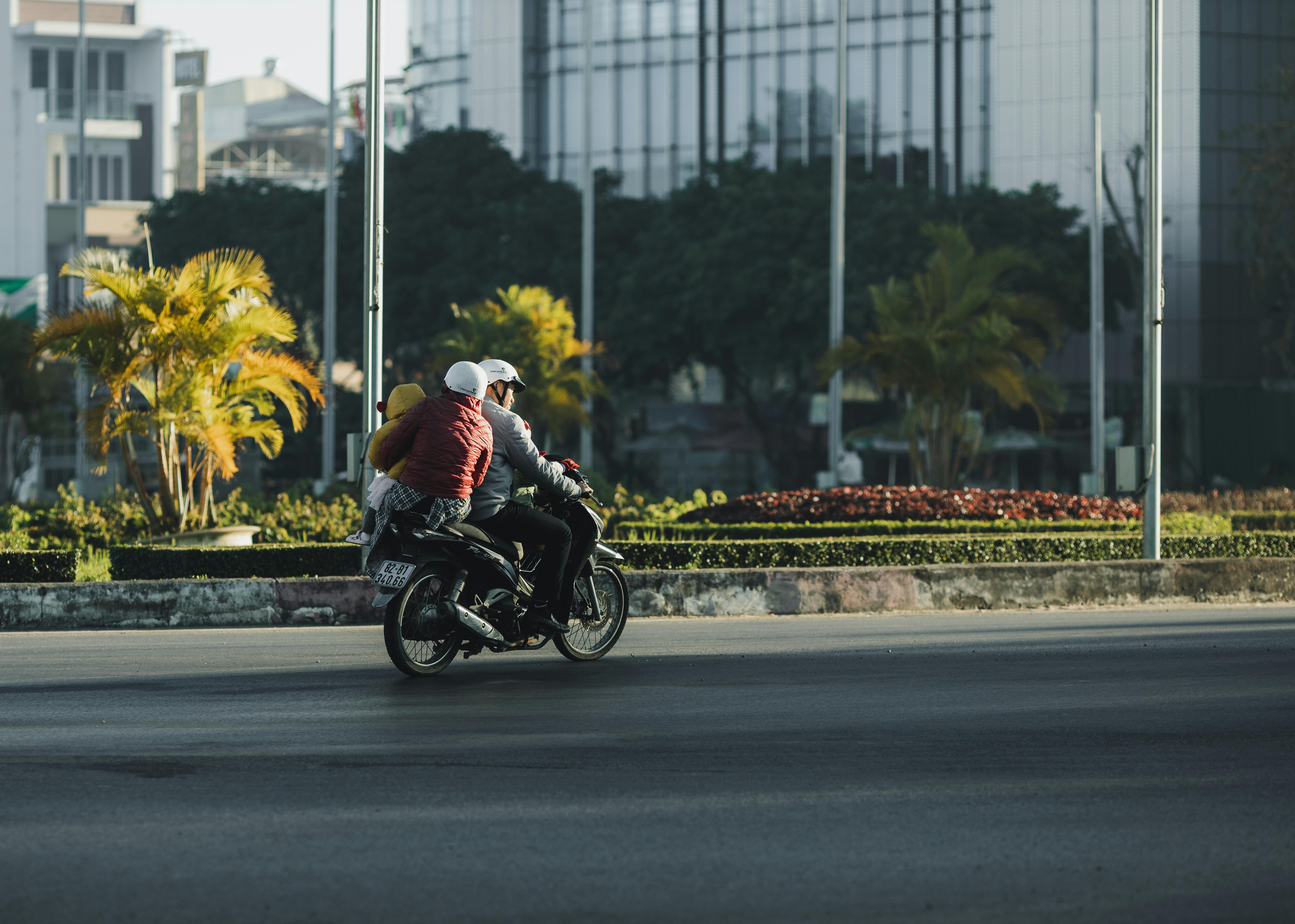 A motorbike carrying multiple passengers travels along a wide urban road in Vietnam, highlighting everyday transport on busy city streets | Source: Pexels