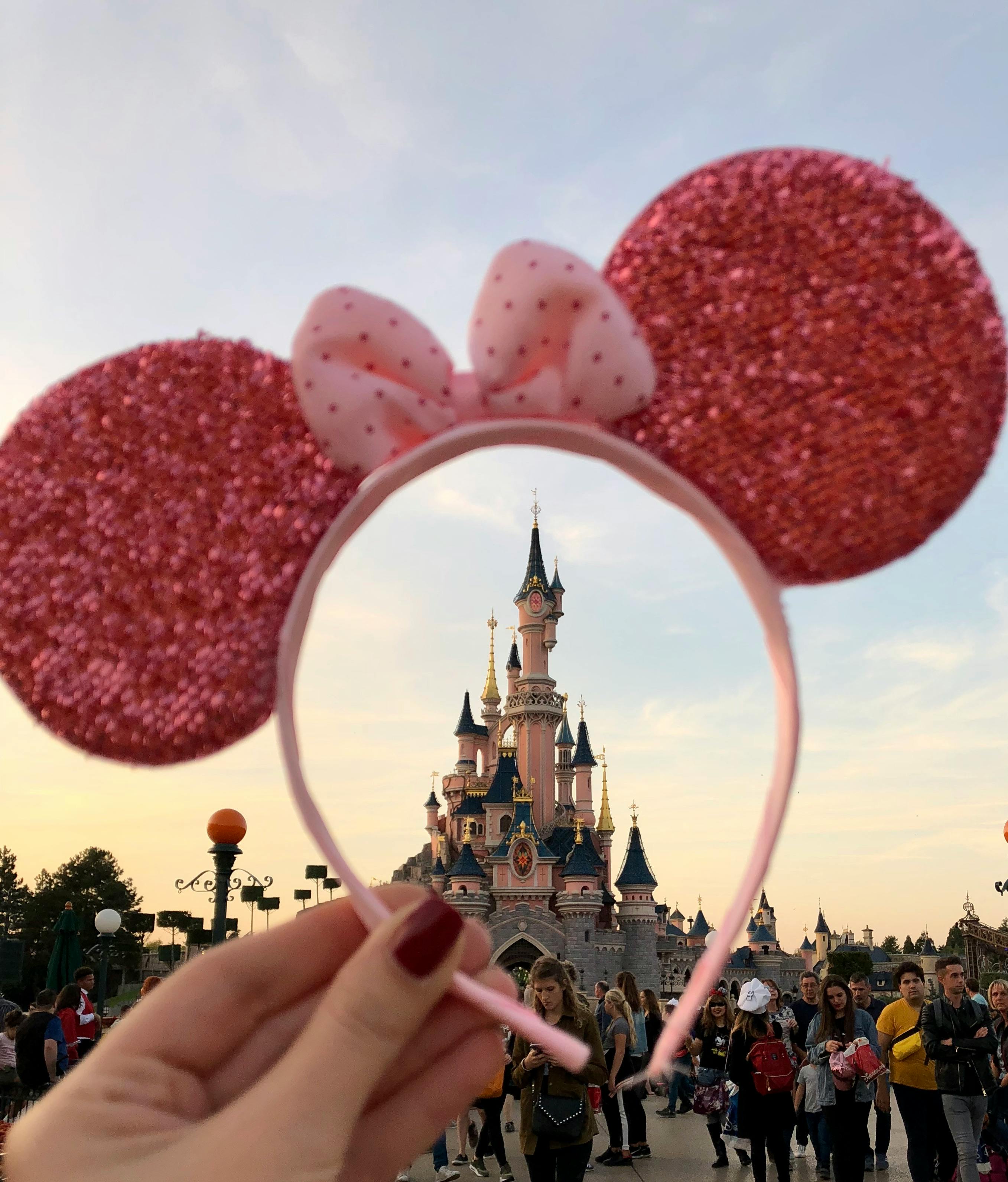 A woman holding a sparkly mouse ears headband | Source: Pexels