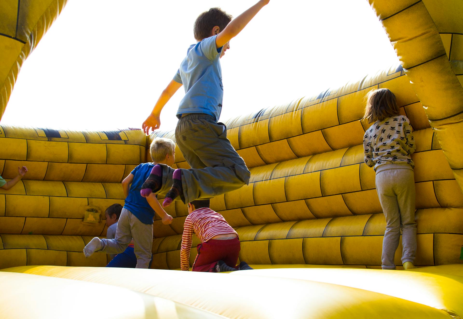 Children playing on an inflatable castle | Source: Pexels